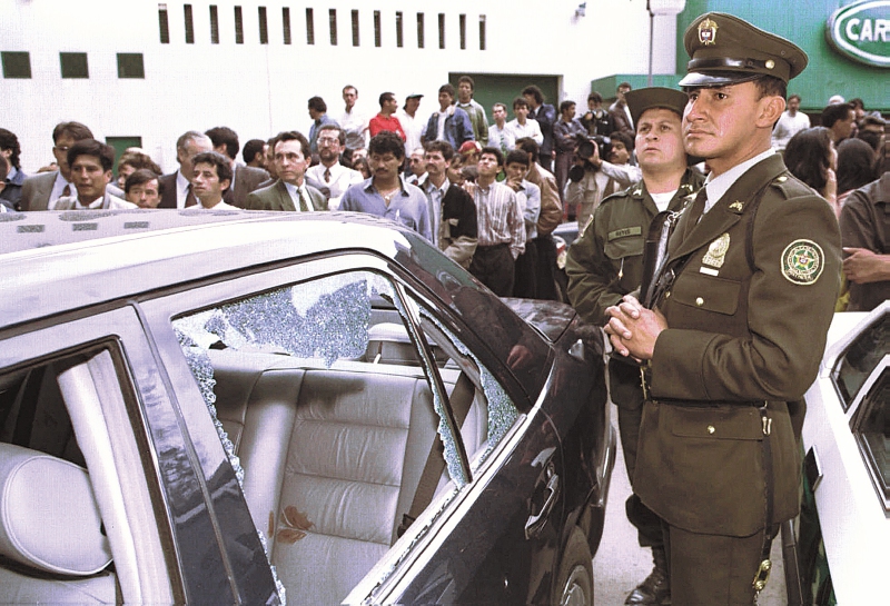 La policía colombiana junto al vehículo donde Álvaro Gómez Hurtado, exembajador colombiano, fue asesinado el jueves 2 de noviembre de 1995. El ataque ocurrió cerca de la entrada de la Universidad Sergio Arboleda, donde Gómez impartía una clase de derecho. Nadie se atribuyó la responsabilidad de inmediato. Gómez, exsenador del opositor Partido Conservador, se postuló sin éxito a la presidencia en varias ocasiones, la más reciente en 1990.