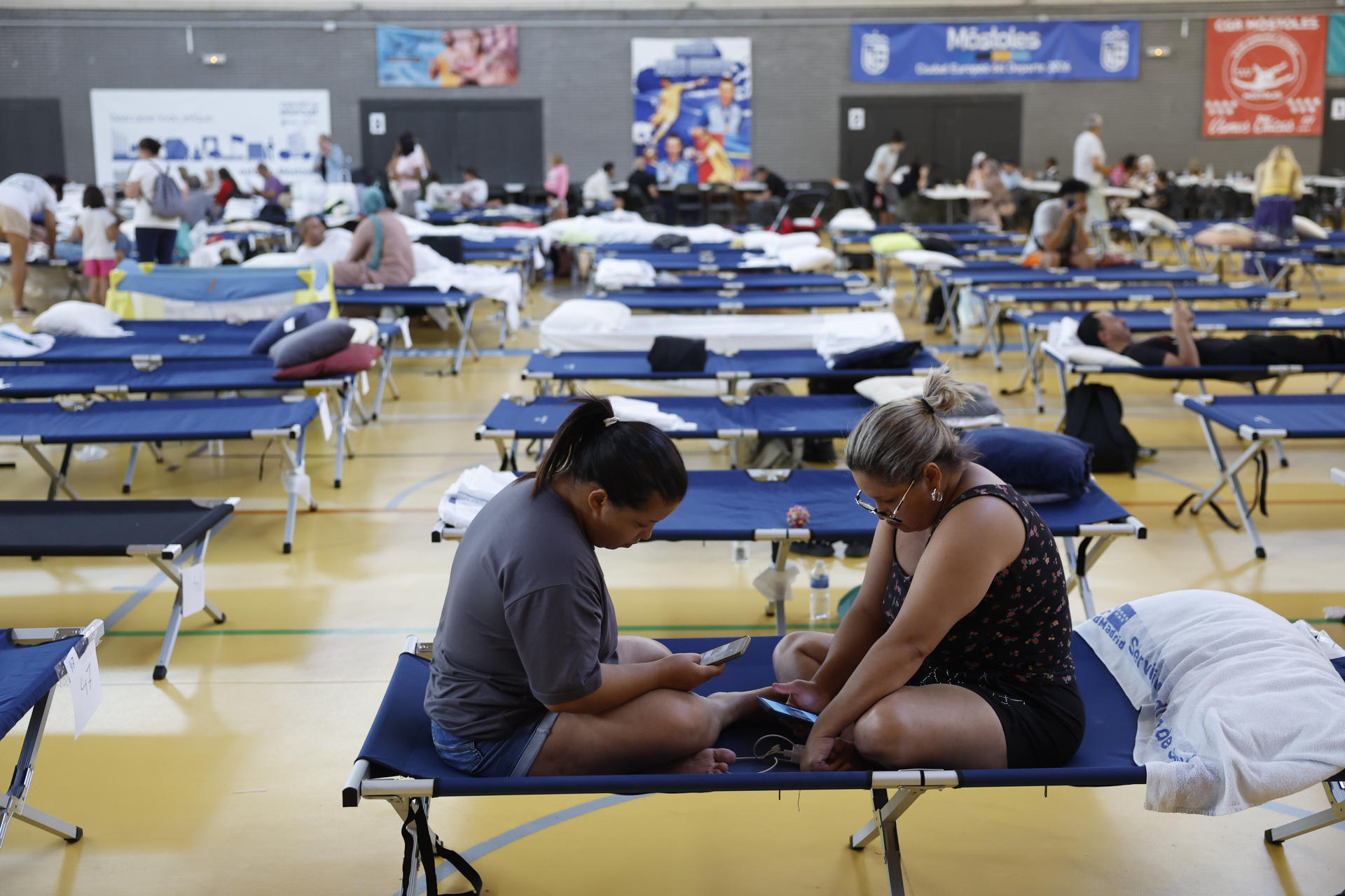 FOTODELDÍA MÓSTOLES (C.A. DE MADRID), 26/07/2026.- Decenas de personas alojadas a primera hora de este domingo en el polideportivo Paco Sedano de Móstoles, uno de los quince puntos de acogida que la Comunidad de Madrid mantiene activos para acoger a evacuados por los incendios de la sierra oeste de la Comunidad de Madrid que continúa activo y sin estabilizar. EFE/Mariscal