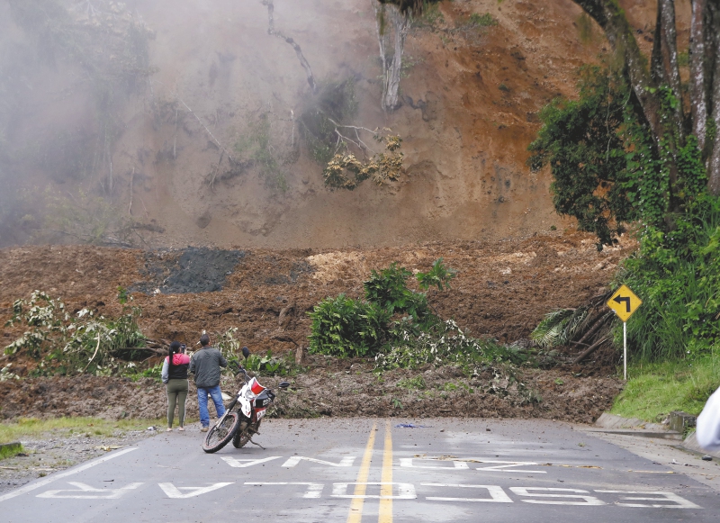 Dos personas observan una carretera bloqueada tras el derrumbe del pasado lunes en Rosas, departamento del Cauca.