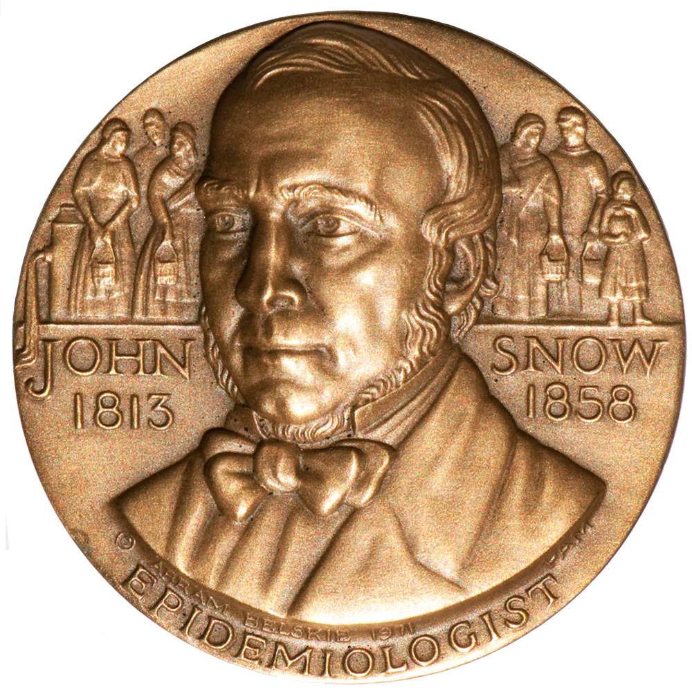 Medalla en honor al doctor John Snow. Bronce (44 mm, 61 g) La medalla en el anverso, documenta los años de su nacimiento (1813) y muerte (1858).  Muestra las personas que reciben agua contaminada con cólera de una bomba del vecindario (arriba a la izquierda) en Londres, Inglaterra.  El reverso de la medalla se centra en 1849, el segundo de dos años (1848-49) cuando el cólera regresó a Londres, luego de la epidemia anterior de 1831-1832. Las personas en el Londres industrial (simbolizado por el humo que sale de una fábrica) se enfermaron al consumir agua contaminada, como lo ilustra el agua que fluye desde la bomba a la derecha. Se está arrojando una campana en la parte superior de la medalla, luego de una muerte por cólera. En el lado derecho, una madre sostiene a su bebé, preocupado de que el cólera lo afecte, mientras observa a un hombre sostener a una persona enferma o muerta.