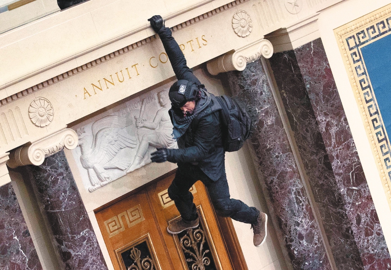 WASHINGTON, DC - JANUARY 06: A protester supporting U.S. President Donald Trump jumps from the public gallery to the floor of the Senate chamber at the U.S. Capitol Building on January 06, 2021 in Washington, DC. Congress held a joint session today to ratify President-elect Joe Biden's 306-232 Electoral College win over President Donald Trump. A group of Republican senators said they would reject the Electoral College votes of several states unless Congress appointed a commission to audit the election results Win McNamee/Getty Images/AFP
== FOR NEWSPAPERS, INTERNET, TELCOS & TELEVISION USE ONLY ==