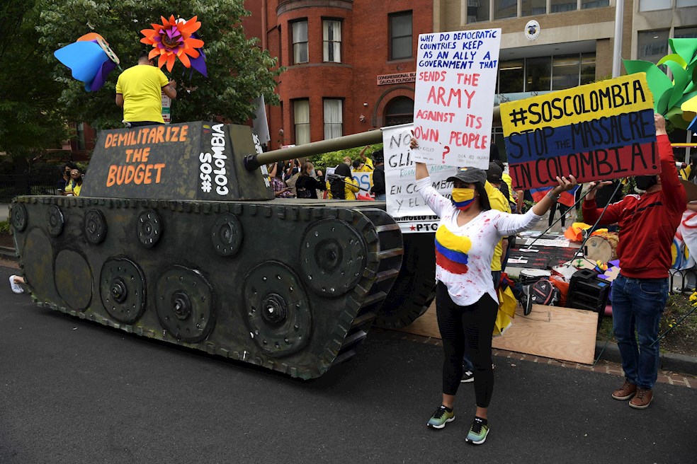 Colombianos protestan junto a la réplica de una tanqueta que pide la "desmilitarización del presupuesto" durante una concentración al frente del consulado colombiano en Washington para pedir el cese de la violencia en su país, hoy en Washington (EE.UU.).