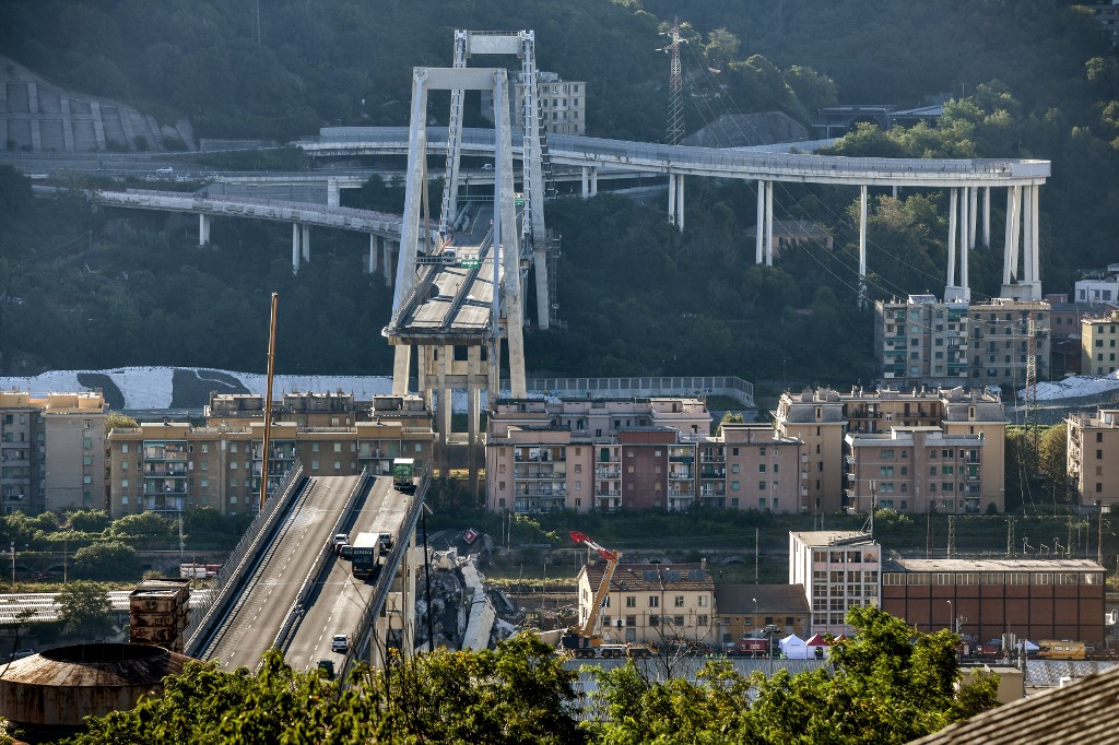 (FILES) This file photo taken on August 15, 2018 shows a general view of abandoned vehicles on the Morandi motorway bridge after a section collapsed in the north-western Italian city of Genoa. - Italy inaugurates a sleek new bridge in Genoa on August 3, 2020, though relatives of the 43 people killed when the old viaduct collapsed say the pomp and ceremony risk overshadowing the tragedy. (Photo by Piero CRUCIATTI / AFP)
