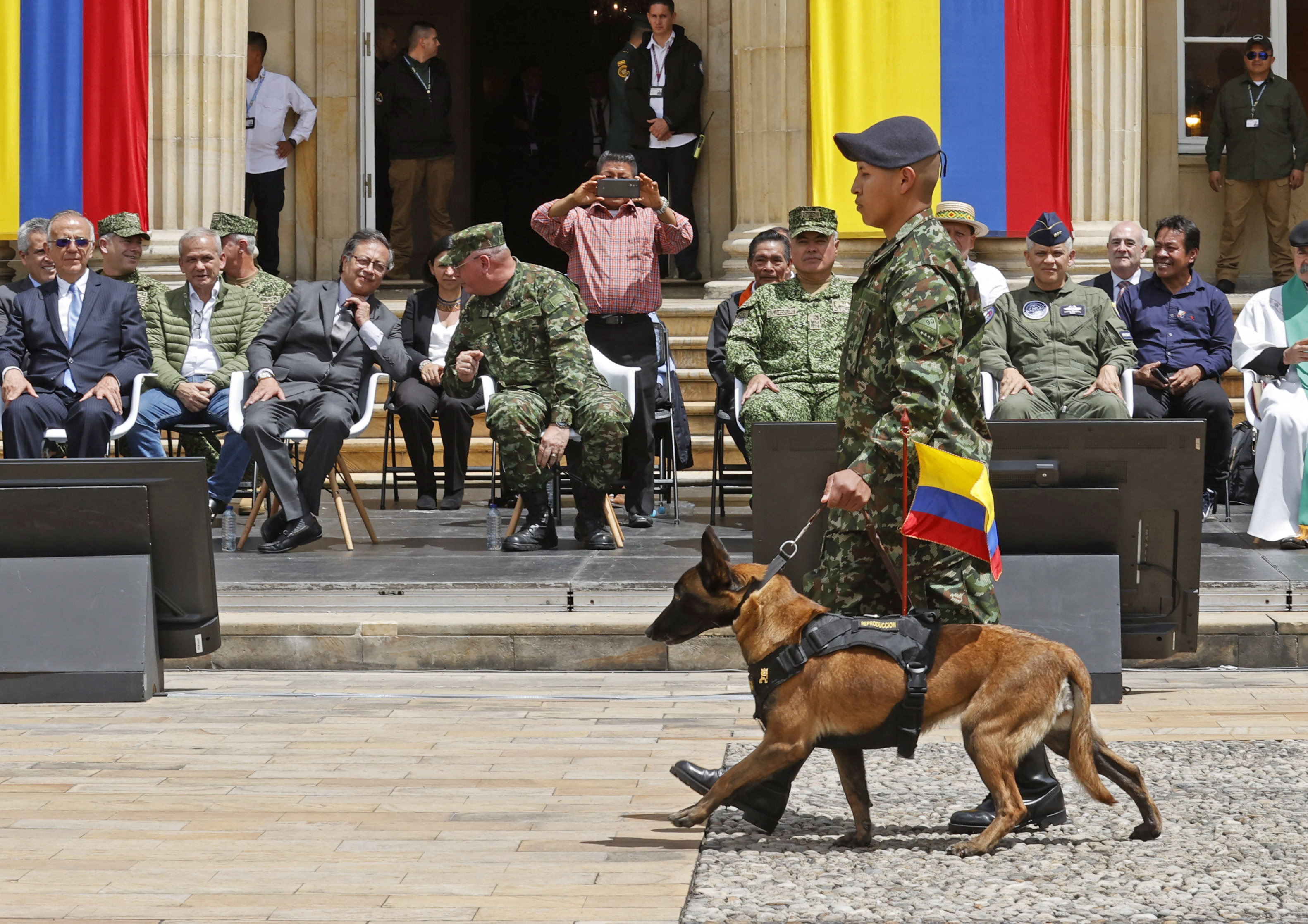 AME9099. BOGOTÁ (COLOMBIA), 26/06/2023.- Un militar camina hoy, frente al presidente de Colombia Gustavo Petro (2-i), con la mamá de Wilson perro que ayudo al rescate de los niños indígenas que estuvieron perdidos en la selva durante cuarenta días y que durante el operativo se perdió en la selva, en el Palacio de Nariño, en Bogotá (Colombia). EFE/ Mauricio Dueñas Castañeda