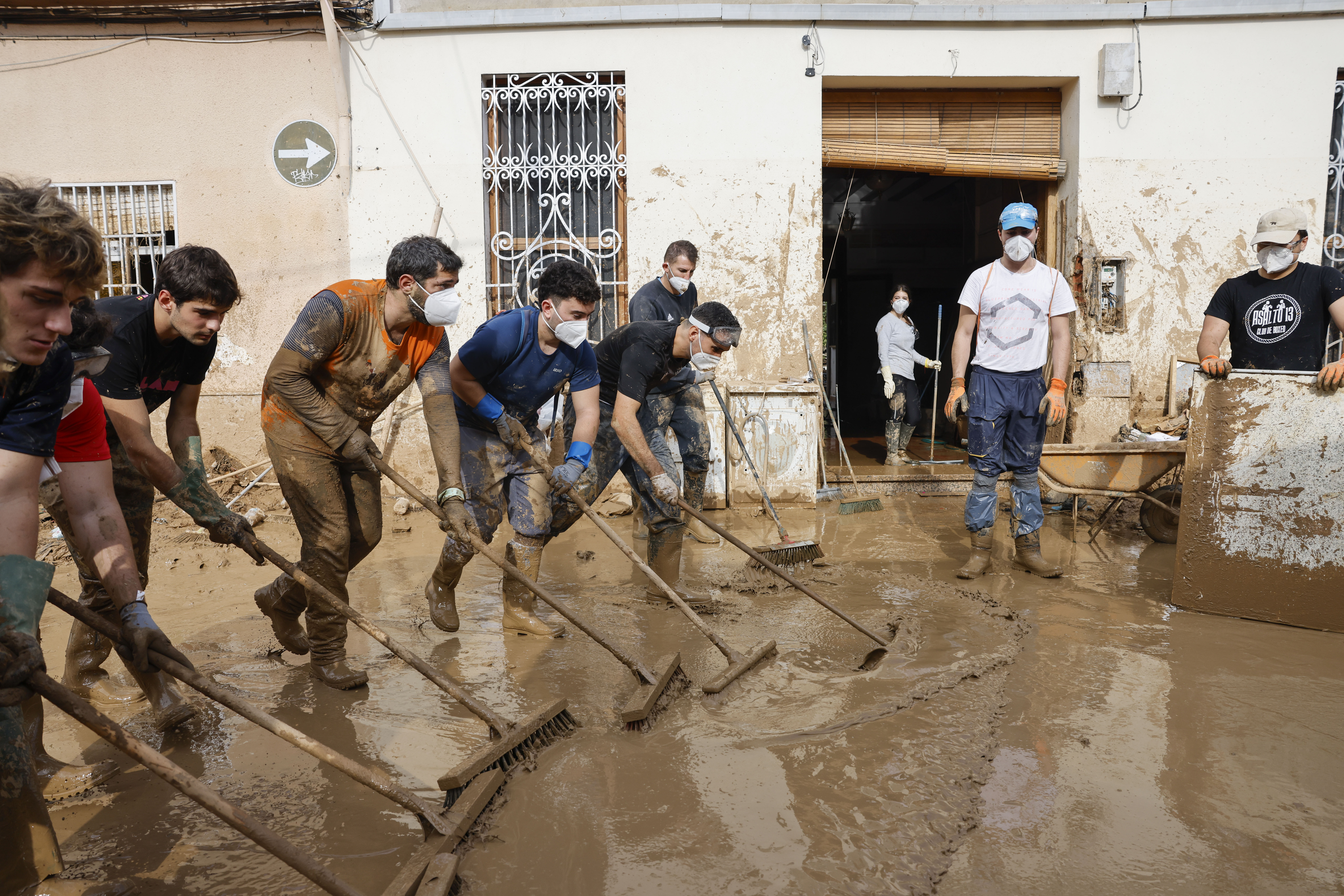 MASANASA (VALENCIA), 07/11/2024.-  Voluntarios barren el lodo de una calle de Masanasa, Valencia, este jueves. Los pueblos de Valencia asolados por la dana afrontan el noveno día después de la catástrofe sumidos en un goteo incesante de llegada tanto de ayuda humanitaria como profesional y de maquinaria pesada, para intentar recuperar infraestructuras, colegios, zonas industriales y vías de comunicación mientras continúa la búsqueda de desaparecidos. EFE/Ana Escobar