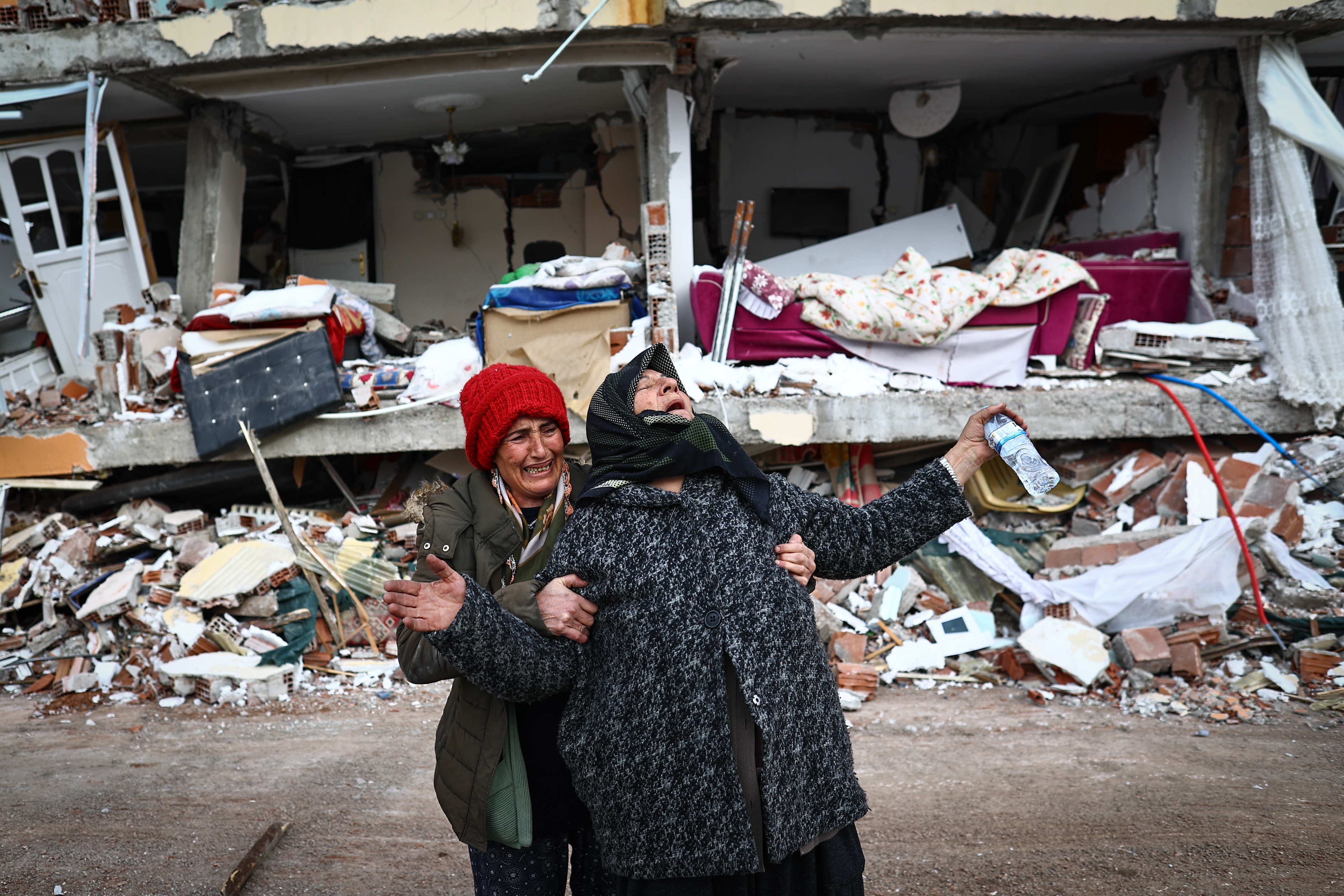 -FOTODELDIA- Elbistan (Turquía), 08/02/2023.- Dos mujeres se lamentan junto a un edificio derrumbado tras el gran terremoto en el distrito de Elbistan de Kahramanmaras, Turquía, el 08 de febrero de 2023. Más de 9.000 personas han muerto y miles han resultado heridos después de que dos grandes terremotos azotaran el sur de Turquía y el norte de Siria el 6 de febrero. Las autoridades temen que el número de muertos siga aumentando mientras los rescatistas buscan supervivientes en toda la región. EFE/SEDAT SUNA