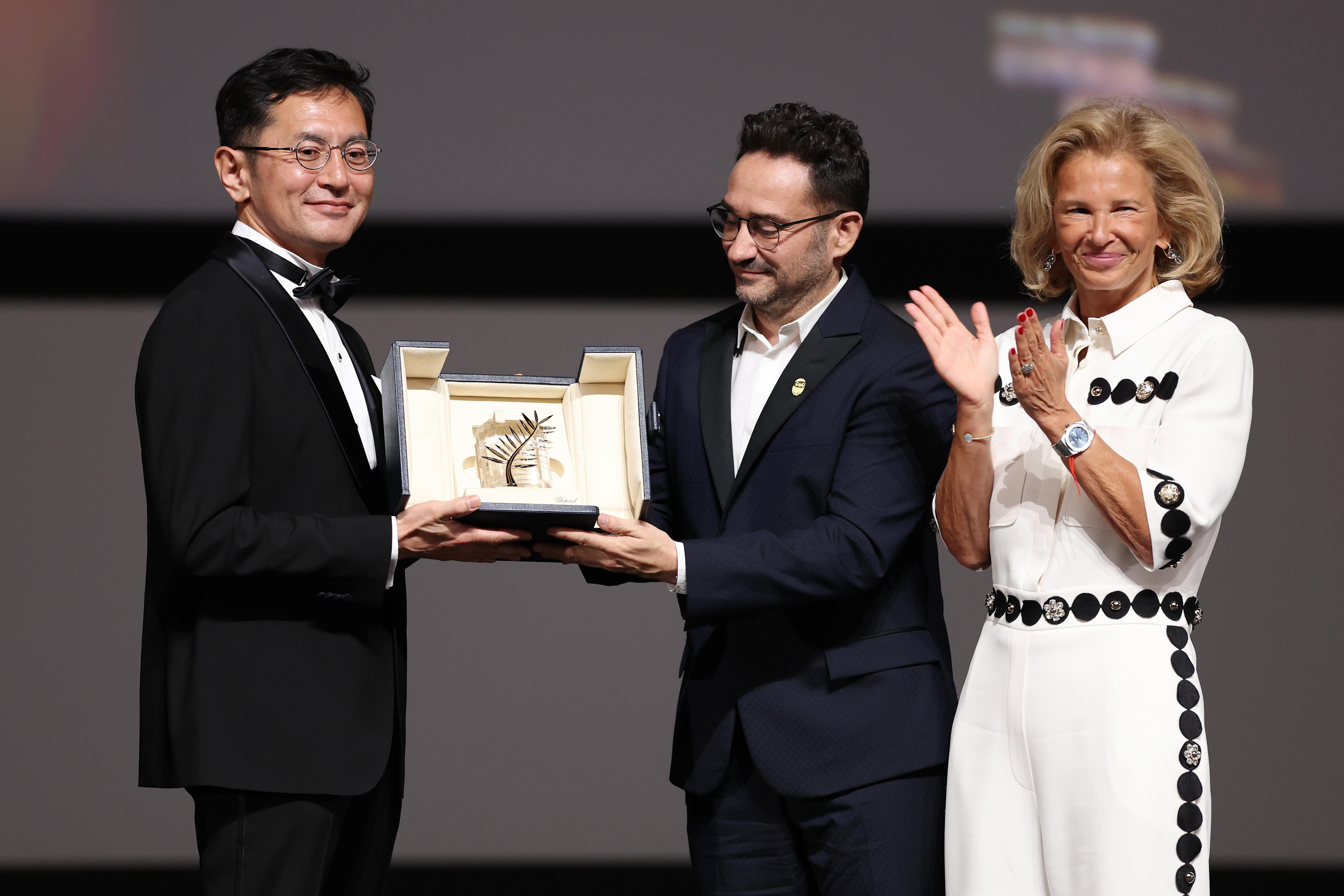 Cannes (France), 20/05/2024.- Goro Miyazaki (L) receives the award from jury member Juan Antonio Bayona (C) and president of the festival Iris Knobloch (R) during the Palme D'Or awarding ceremony during the 77th annual Cannes Film Festival, in Cannes, France, 20 May 2024. Studio Ghibli will receive the 'Palme d'Or d'Honneur', the honorary Golden Palm Award at the film festival which runs from 14 to 25 May 2024. (Cine, Francia) EFE/EPA/PASCAL LE SEGRETAIN / POOL *** Local Caption *** CANNES, FRANCE - MAY 20: Goro Miyazaki poses with the award during the ceremony for the Palme D'Or D'Honneur to Studio Ghibli at the 77th annual Cannes Film Festival at Palais des Festivals on May 20, 2024 in Cannes, France. (Photo by Pascal Le Segretain/Getty Images)