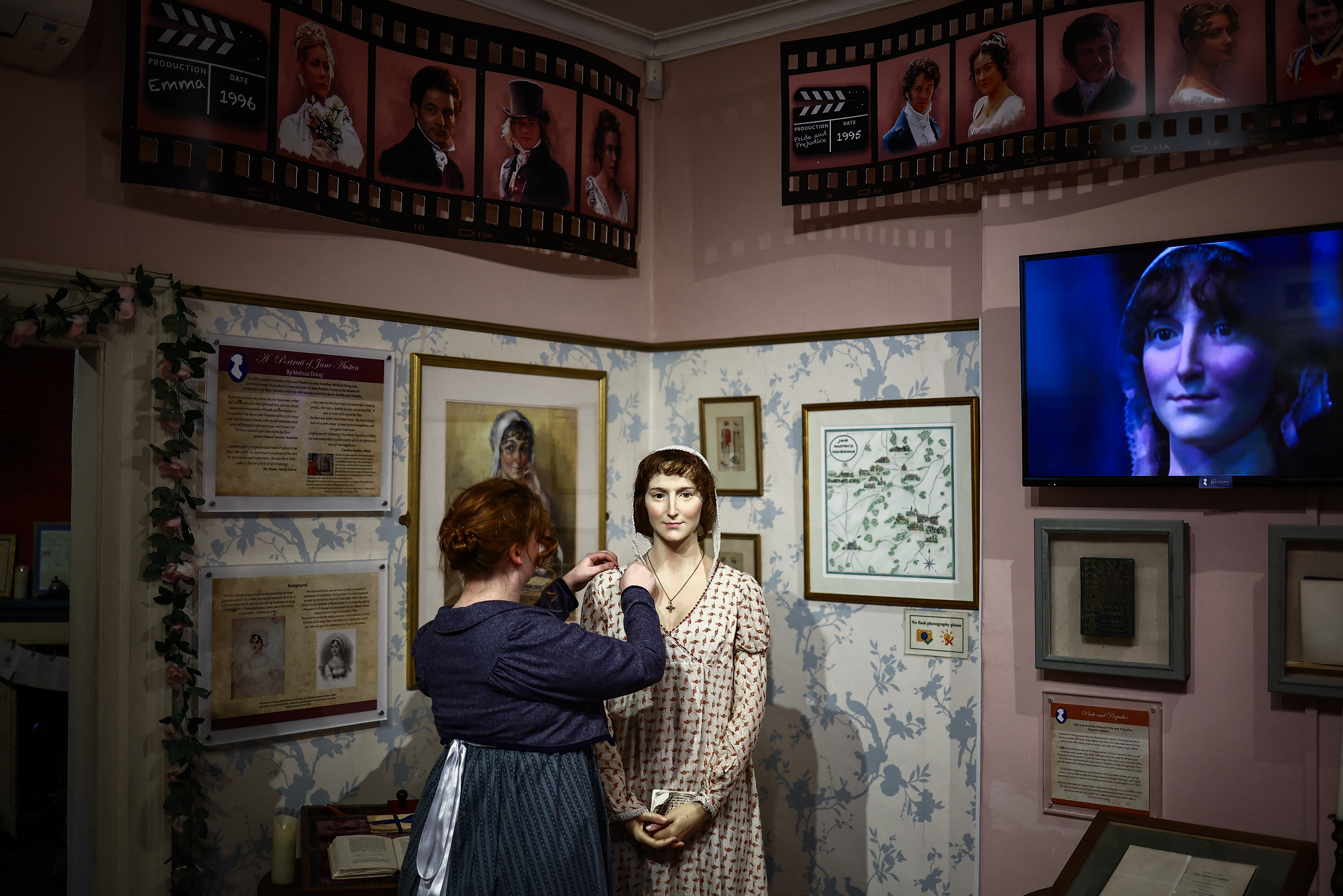 A regency actor who works at the Jane Austen Centre adjusts a waxwork model of Jane Austen, in Bath, Somerset on February 14, 2025.