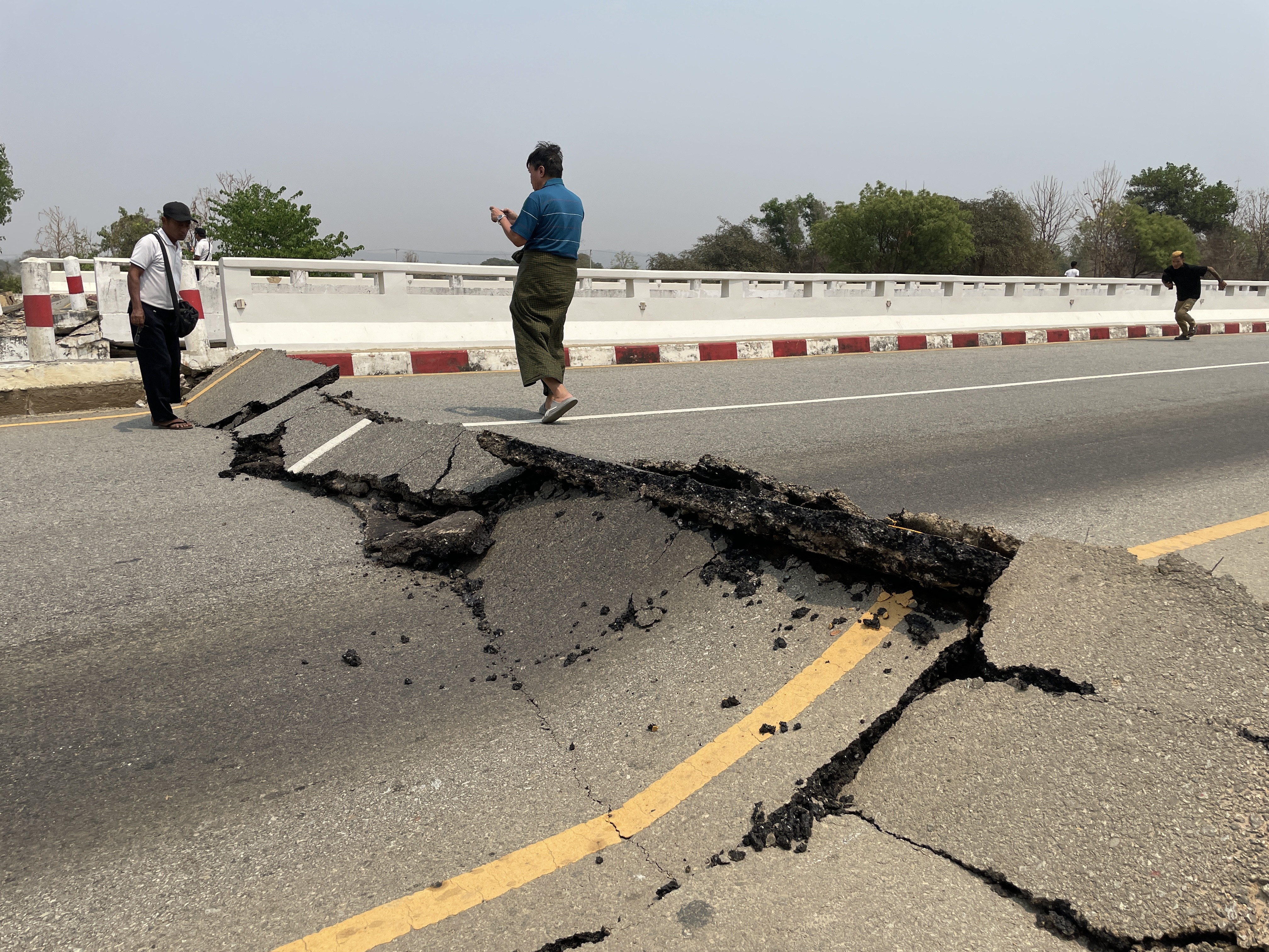 Naypyidaw (Myanmar), 28/03/2025.- People look at a damaged bridge on the Naypyidaw-Yangon highway after an earthquake, in Naypyidaw, Myanmar, 28 March 2025. A 7.7-magnitude earthquake struck Myanmar, according to the United States Geological Survey (USGS), with tremors felt in neighboring countries (Terremoto/sismo, Birmania, Estados Unidos) EFE/EPA/NYEIN CHAN NAING