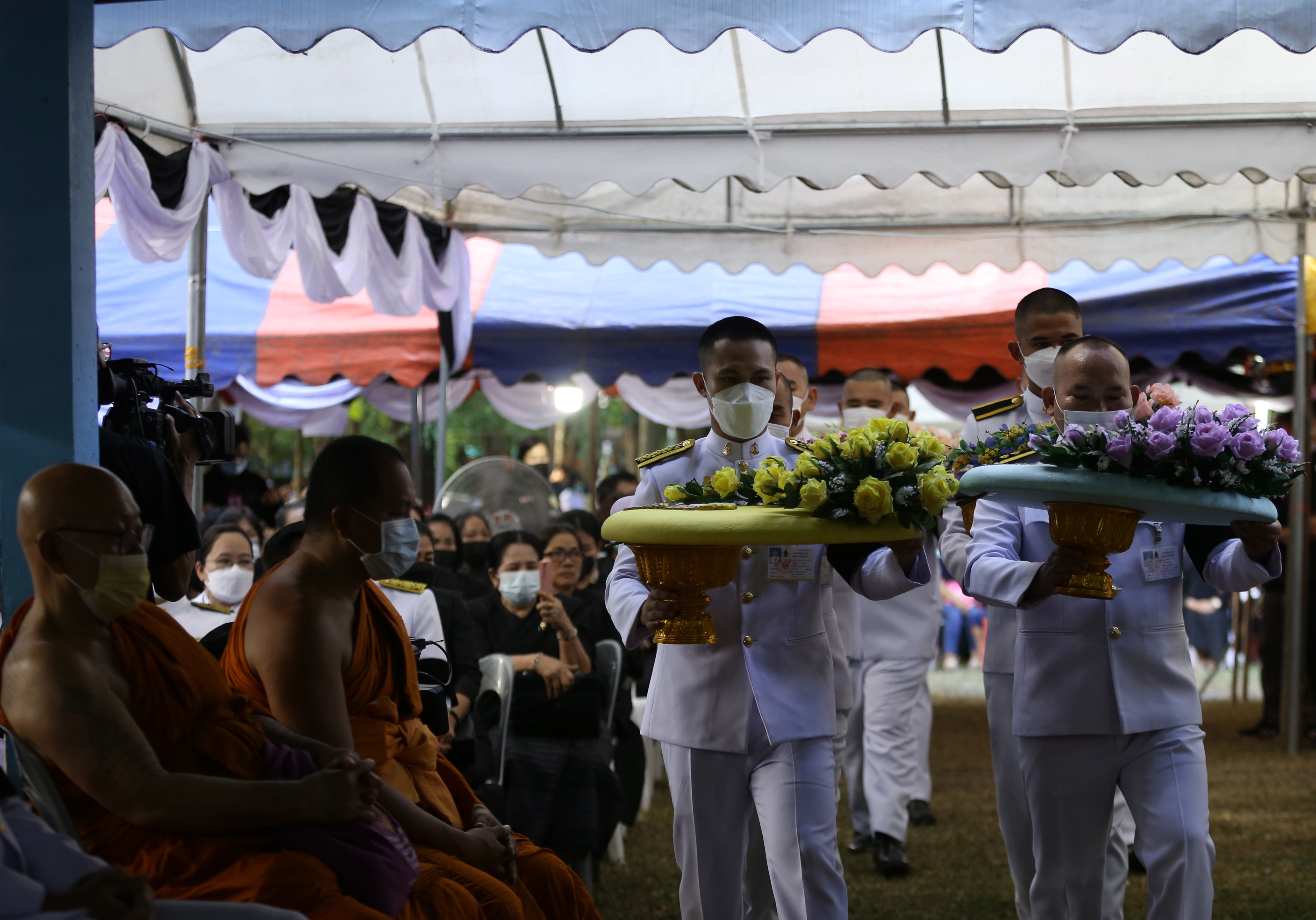 Oficiales reales llevan la corona del rey tailandés y la familia real para llorar a los fallecidos durante la ceremonia religiosa fúnebre en un templo budista en la provincia de Nong Bua Lamphu.