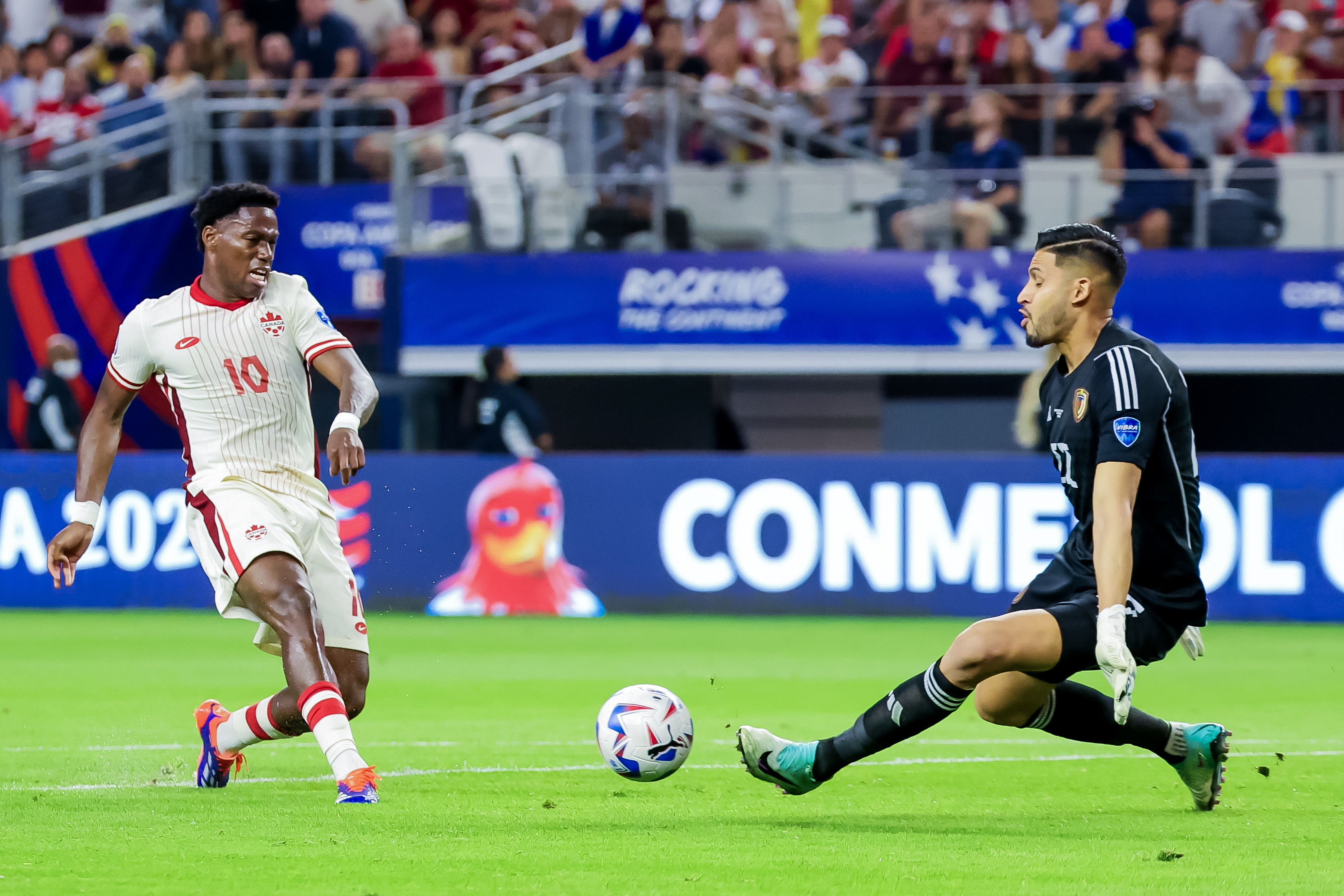 Arlington (United States), 06/07/2024.- Jonathan David (L) of Canada in action against goalkeeper Rafael Romo (R) of Venezuela during the first half of the CONMEBOL Copa America 2024 Quarter-finals match between Venezuela and Canada, in Arlington, Texas, USA, 05 July 2024. EFE/EPA/KEVIN JAIRAJ