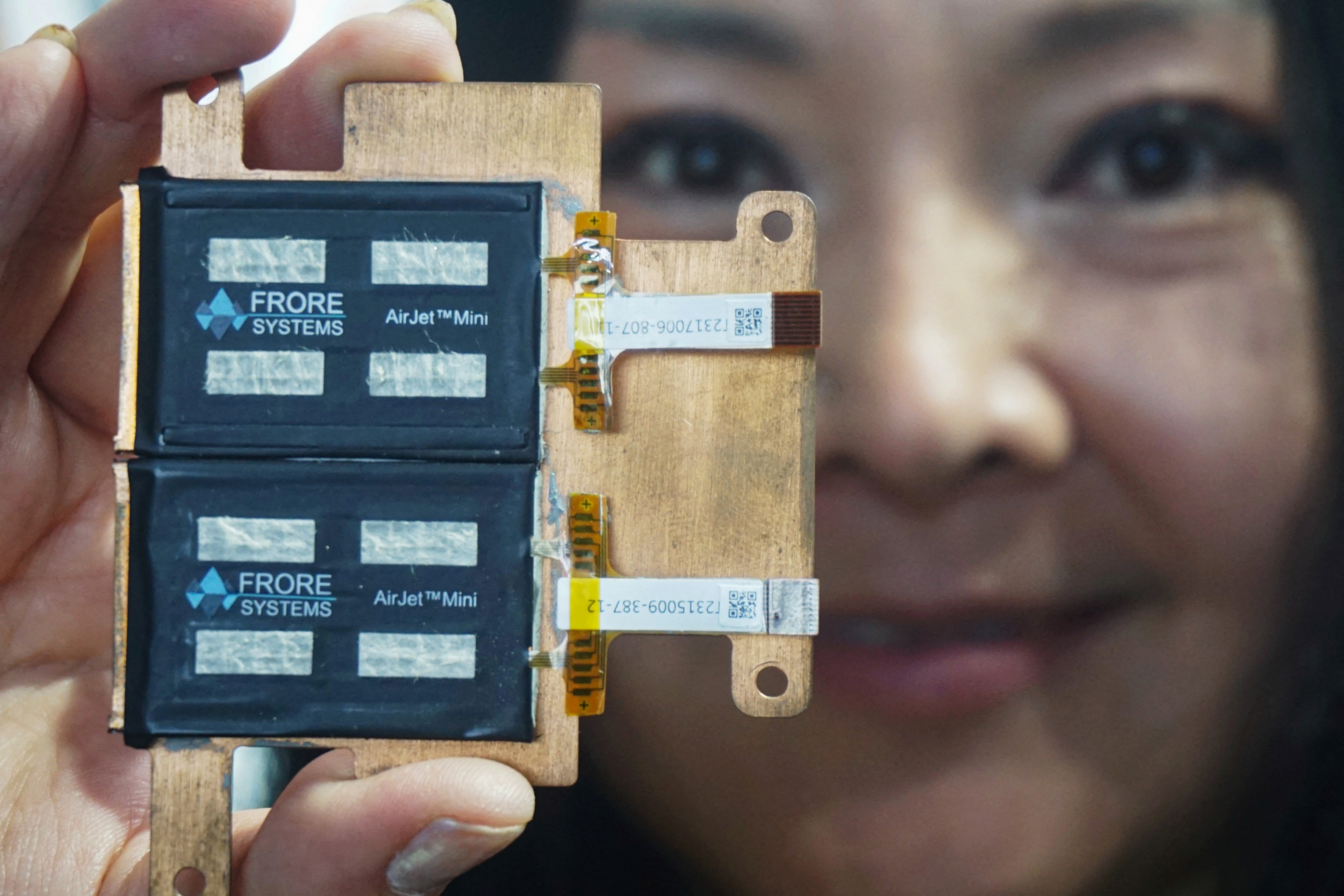 A woman holds AirJet device, a solid-state chip with active cooling technology developed by Frore Systems, at the Mobile World Congress (MWC) in Shanghai on June 26, 2024. (Photo by AFP) / CHINA OUT