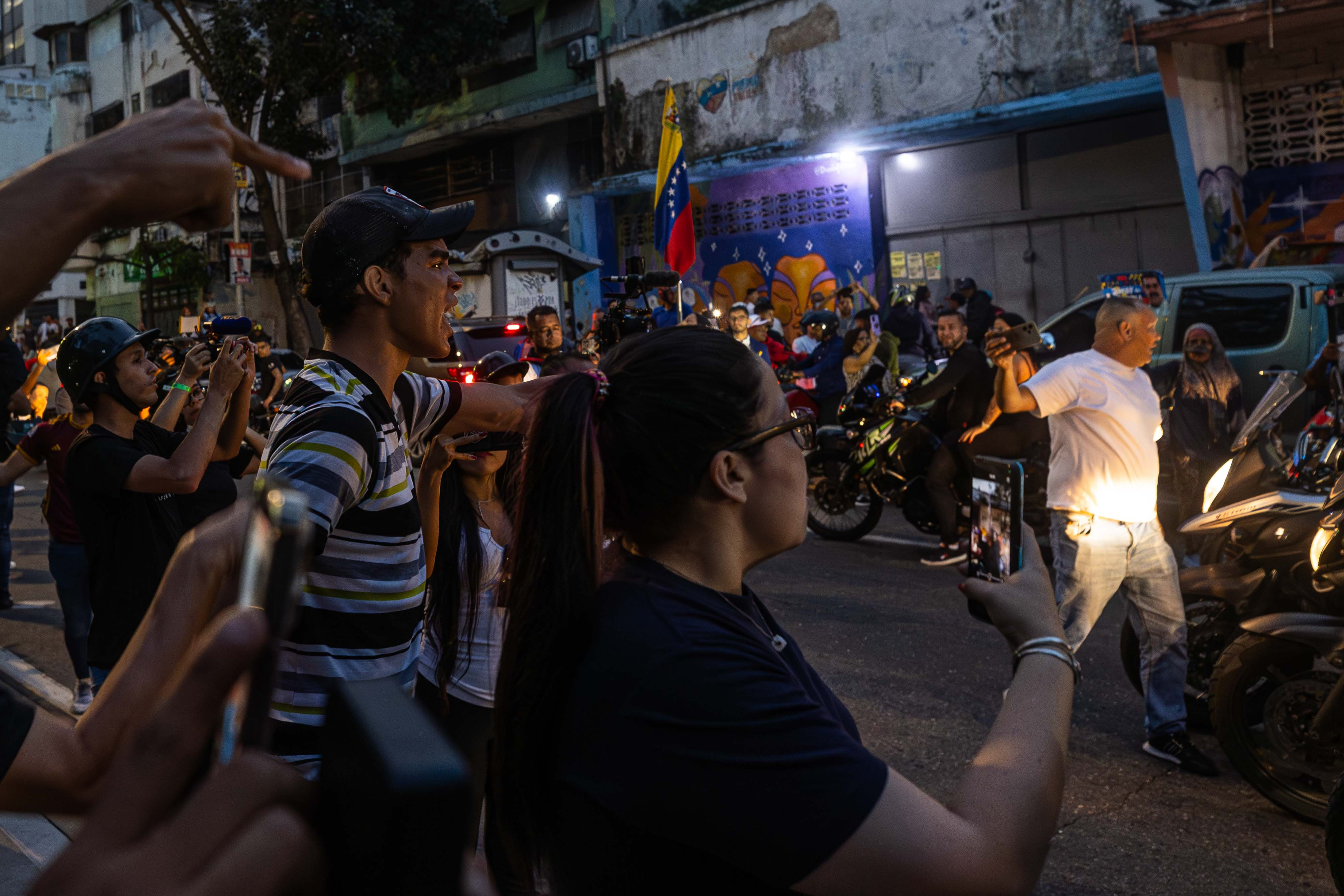 AME6008. CARACAS (VENEZUELA), 28/07/2024.- Seguidores del presidente de Venezuela y candidato a la reelección, Nicolás Maduro, se enfrentan desde una caravana de motocicletas con personas este domingo, en Caracas (Venezuela). Varias decenas de motorizados que se identificaron como chavistas llegaron a un centro de votación en Caracas, donde se encontraban testigos opositores y ciudadanos que esperaban el comienzo del escrutinio de las elecciones presidenciales de este domingo, lo que dio lugar a una confrontación que acabó a golpes, ante la mirada impasible de los policías, que no intervinieron para detener la pelea. EFE/ Henry Chirinos