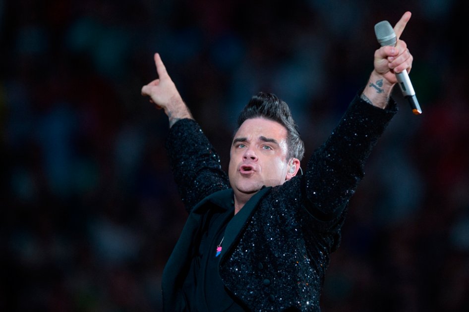 Robbie Williams besa y firma la cola de una fan