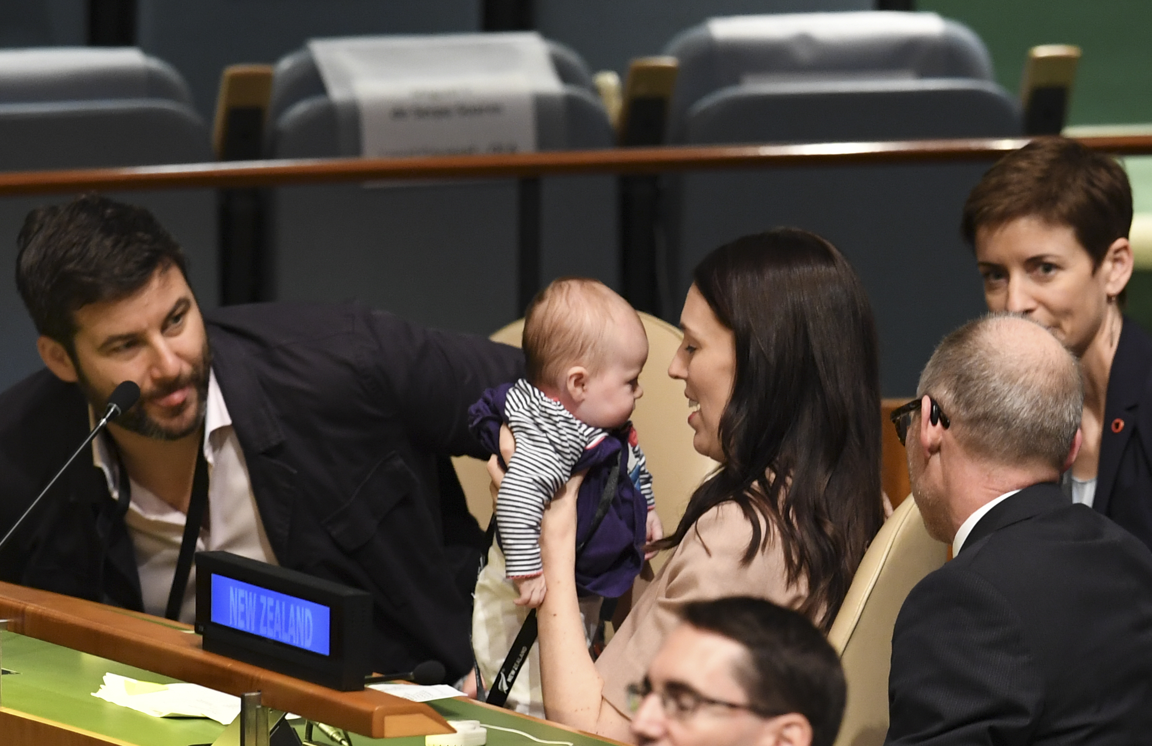 Jacinda Ardern, Prime Minister and Minister for Arts, Culture and Heritage, and National Security and Intelligence of New Zealand holds her daughter Neve Te Aroha Ardern Gayford, as her partner Clarke Gayford (L) looks on during the Nelson Mandela Peace Summit September 24, 2018, one day before the start of the General Debate of the 73rd session of the General Assembly at the United Nations in New York. / AFP PHOTO / Don EMMERT