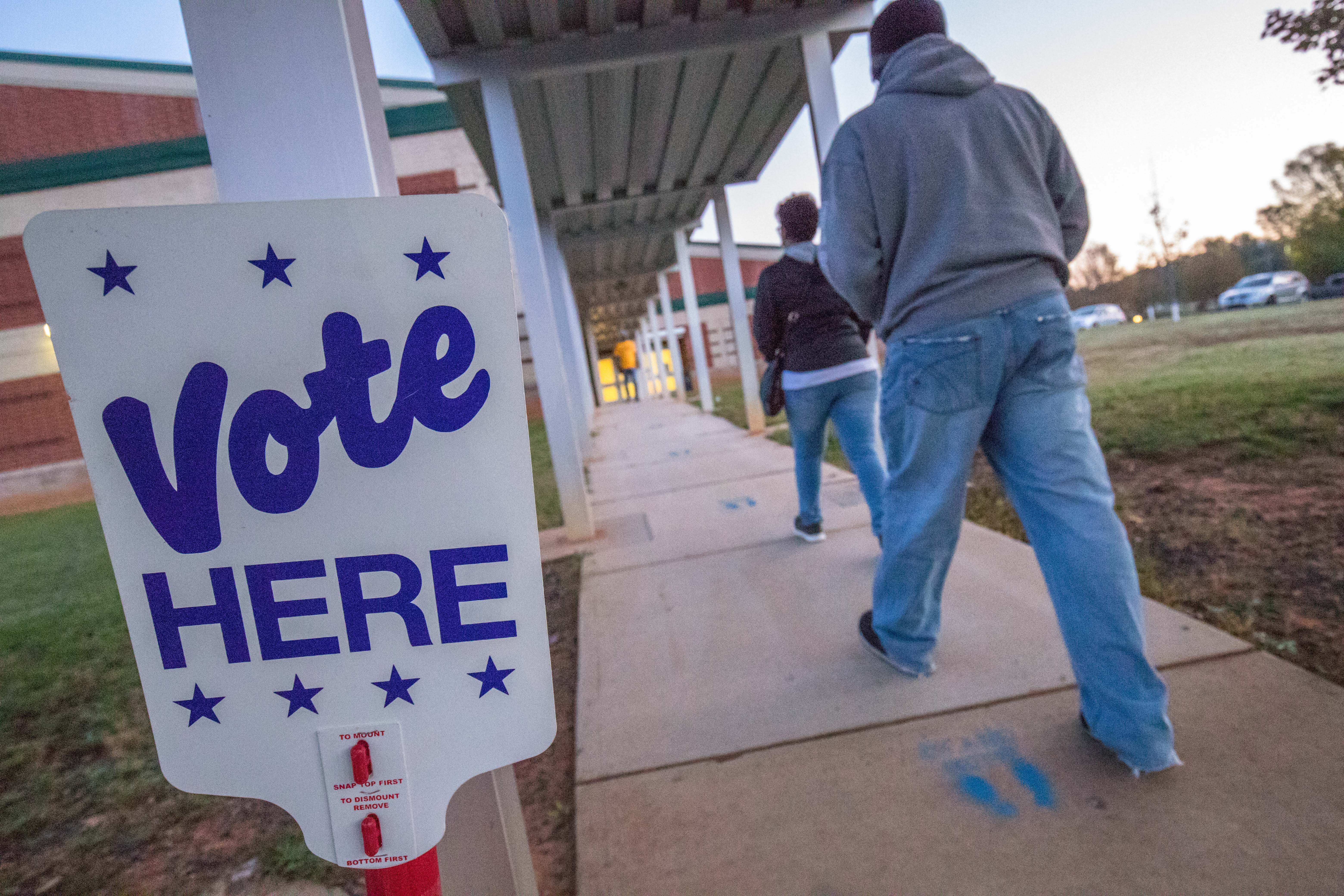 Voters arrive at Waddell Language Academy in Charlotte, North Carolina shortly after the polls opened on November 3, 2020. - The United States started voting Tuesday in an election amounting to a referendum on Donald Trump's uniquely brash and bruising presidency, which Democratic opponent and frontrunner Joe Biden urged Americans to end to restore "our democracy." (Photo by Grant Baldwin / AFP)