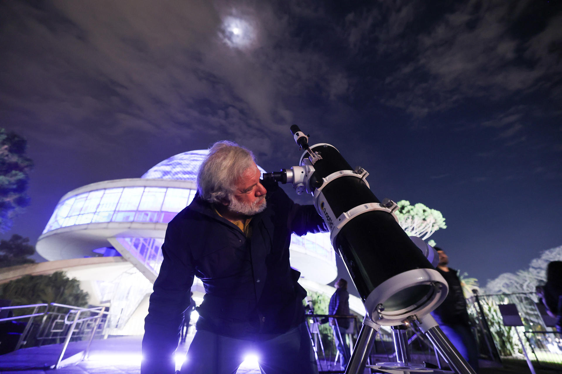 Un hombre observando a través de un telescopio la luna llena durante el eclipse lunar parcial en Buenos Aires (Argentina).