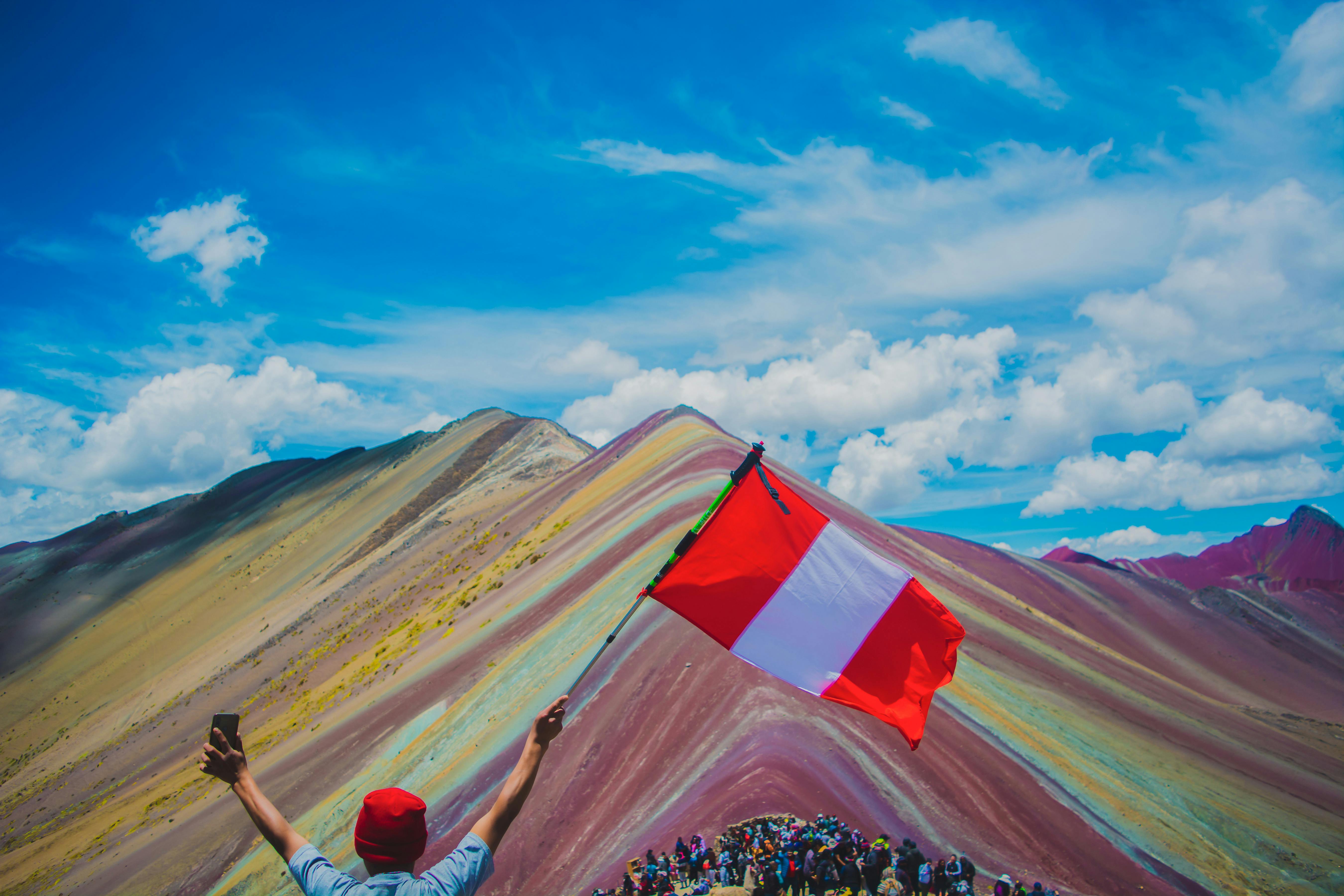 En Perú existen montañas cuyos colores parecen sacados de una pintura, y entre las más impresionantes están Pallay Punchu y Vinicunca. La primera, conocida como el “poncho andino” destaca por sus puntas afiladas, parecidas a unos farallones con franjas rojizas, verdes y marrones que recuerdan los tejidos tradicionales de los Andes, mientras que Vinicunca sorprende con tonos turquesa, lavanda, dorados y ocres formados por minerales acumulados durante millones de años. Ambas se ubican a más de 4.700 metros de altura.
