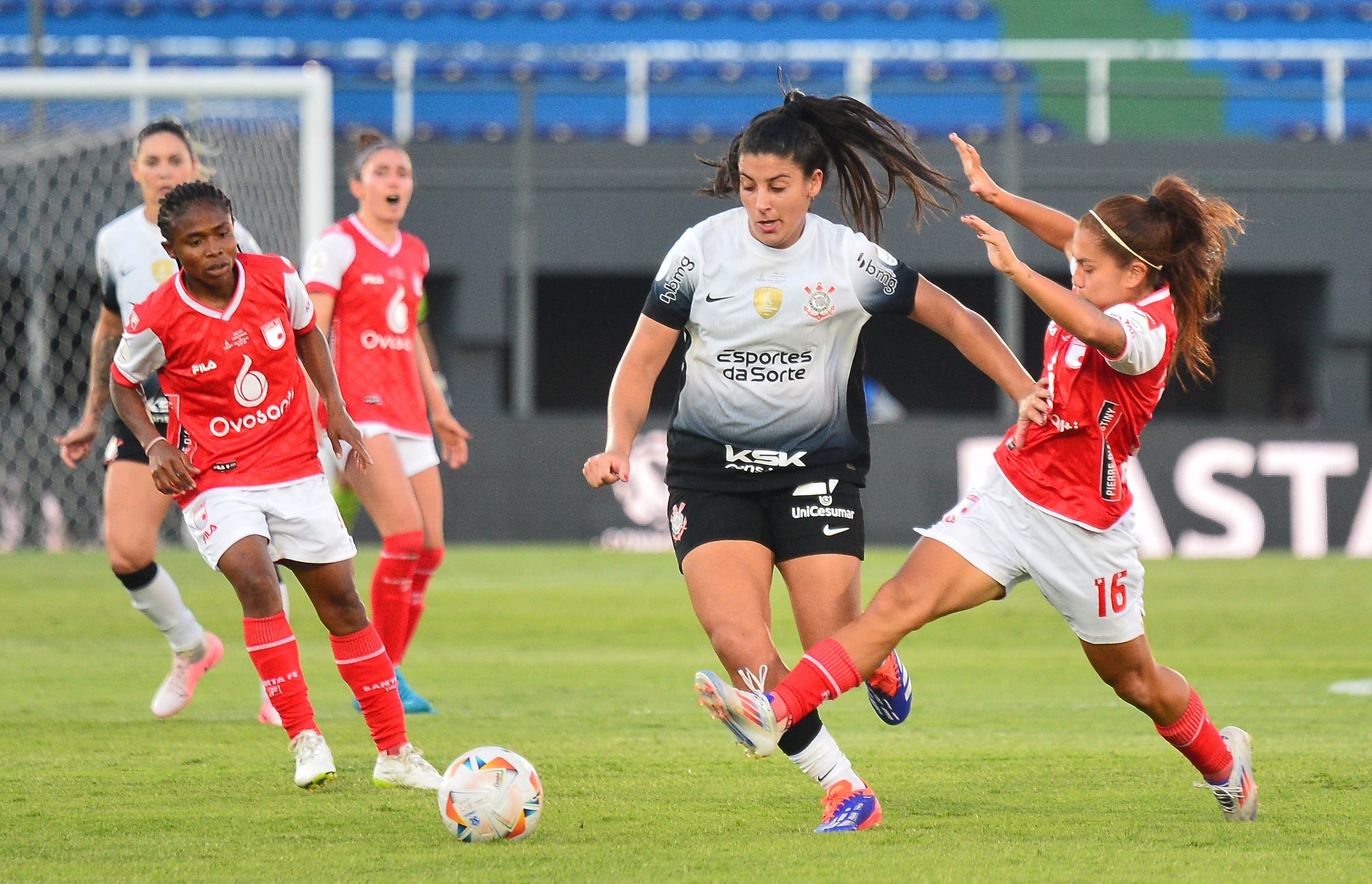 Corinthians' midfielder #27 Duda Sampaio (C) and Independiente Santa Fe's midfielder #16 Karen Hernandez fight for the ball during the 2024 Women Copa Libertadores final match between Brazil's Corinthians and Colombia's Independiente Santa Fe at Defensores del Chaco stadium in Asuncion on October 19, 2024. (Photo by Daniel Duarte                        / AFP)