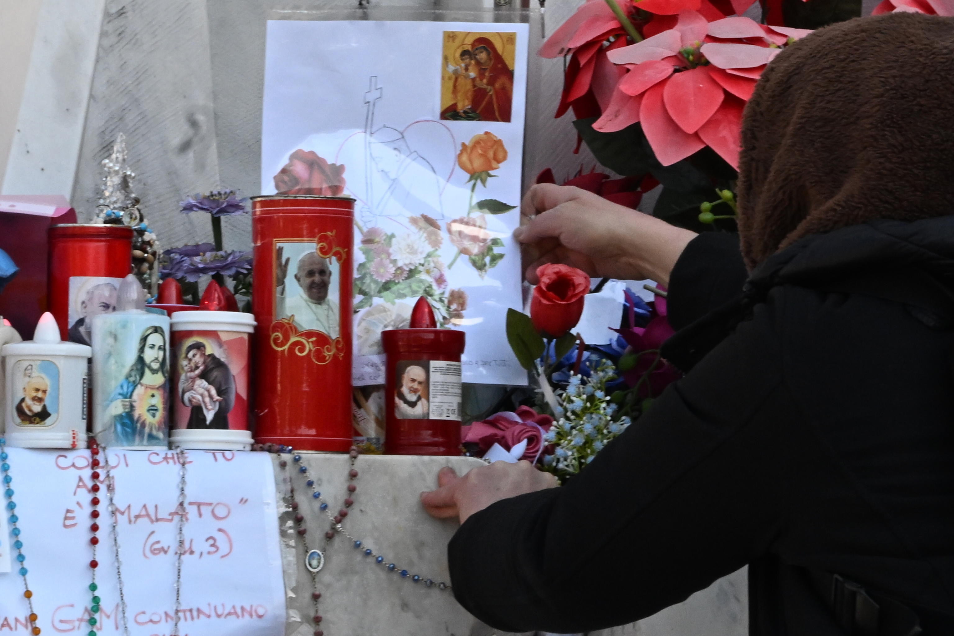 Rome (Italy), 04/03/2025.- A woman leaves a drawing at the base of the statue of Pope John Paul II at Gemelli Hospital, where Pope Francis is hospitalized, in Rome, Italy, 04 March 2025. Pope Francis was admitted to the Agostino Gemelli Hospital in Rome on February 14 due to a respiratory tract infection. According to the Holy See Press Office on the morning of 04 March, Pope Francis slept well throughout the night, and now he continues to rest. (Papa, Santa Sede, Italia, Roma) EFE/EPA/MAURIZIO BRAMBATTI
