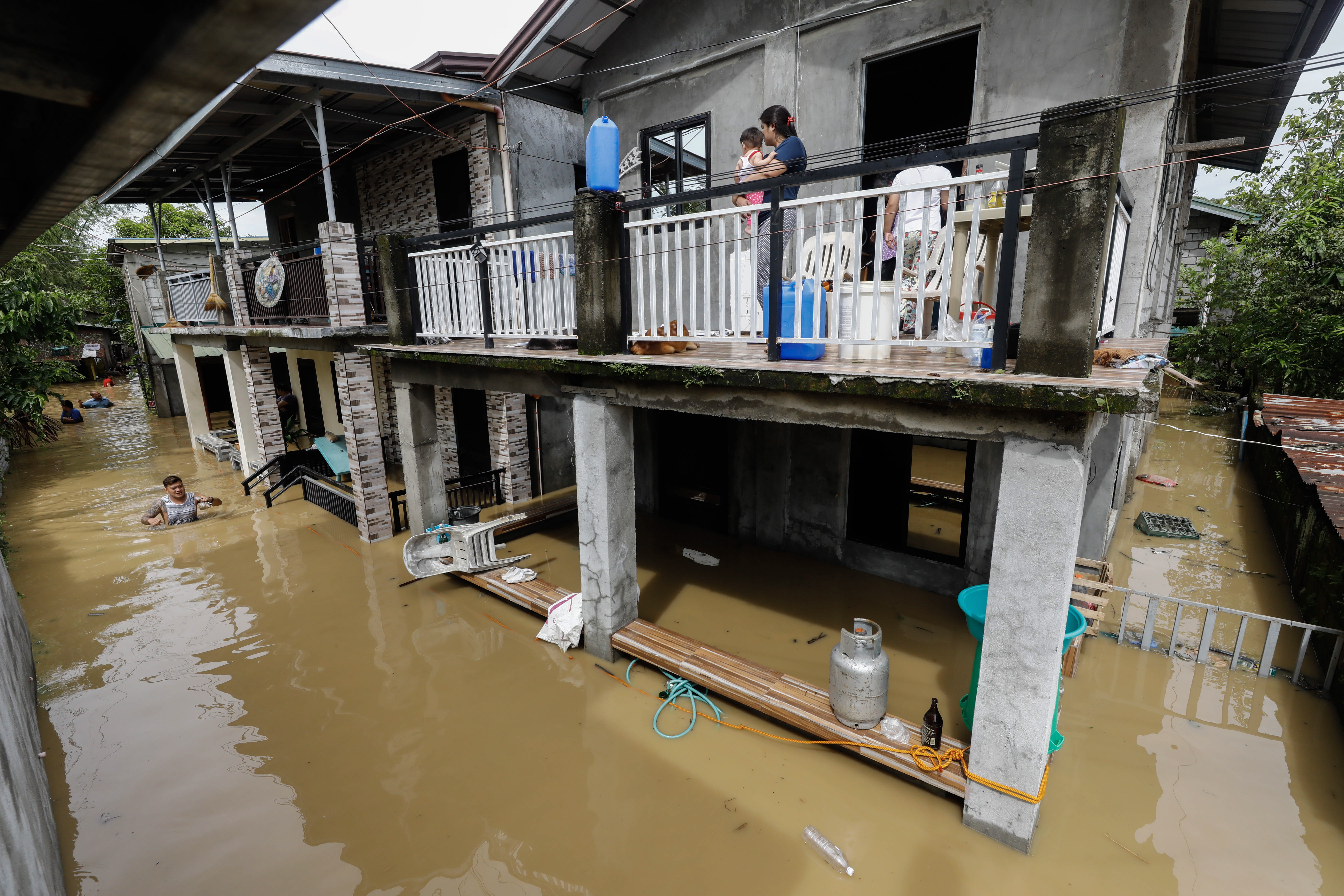 -FOTODELDÍA- EA1212. BULACAN, 26/09/2022.- Una madre y su bebé observan desde la terraza de su vivienda completamente rodeada por el agua que anega la ciudad de San Miguel como consecuencia de las inundaciones provocadas por el tifón Noru en Filipinas. Al menos cinco personas perecieron este lunes y más de 74.000 fueron evacuadas por el paso del tifón, que tocó tierra en el noreste del archipiélago filipino con vientos de hasta 185 kilómetros por hora y que ya ha abandonado la isla de Luzón en dirección oeste. EFE/ Rolex Dela Pena