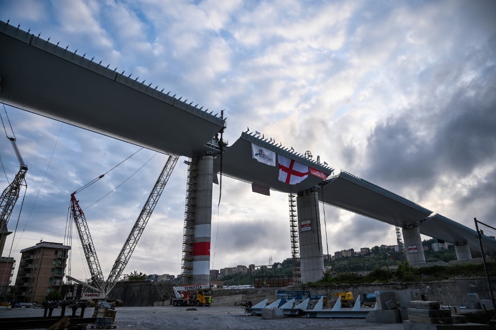 (FILES) This file photo taken on April 27, 2020 shows a view of the last 44 meter long span (Top C) that is being hoisted between columns 10 and 11 on the bridge's eastern side in Genoa, during the country's lockdown aimed at curbing the spread of the COVID-19 infection, caused by the novel coronavirus. - Italy inaugurates a sleek new bridge in Genoa on August 3, 2020, though relatives of the 43 people killed when the old viaduct collapsed say the pomp and ceremony risk overshadowing the tragedy. (Photo by Marco BERTORELLO / AFP)