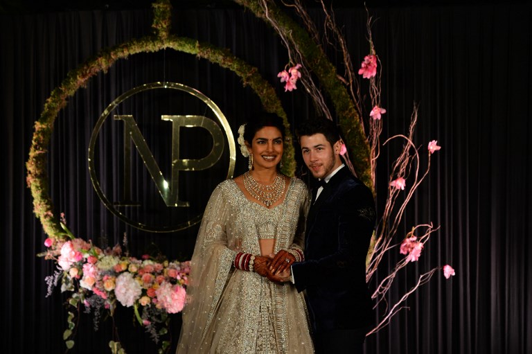 Indian Bollywood actress Priyanka Chopra (L) and US musician Nick Jonas, who were recently married, pose for a photograph during a reception in New Delhi on December 4, 2018. - Bollywood actress Priyanka Chopra and American singer Nick Jonas hosted an extravagant concert on December 2 for their star-studded wedding guests as the couple tied the knot at a lavish Indian palace. (Photo by SAJJAD HUSSAIN / AFP)