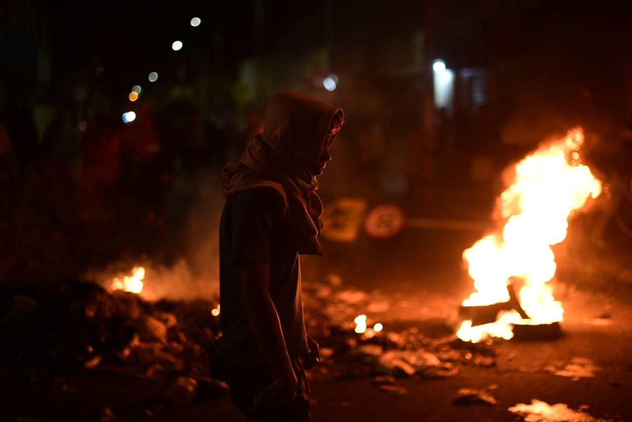 Un hombre camina frente a una llamarada