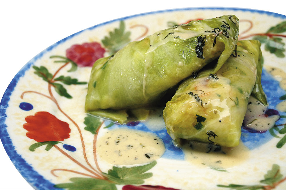 Rollos de repollo rellenos de arroz, camarón y frutos secos con salsa de cilantro