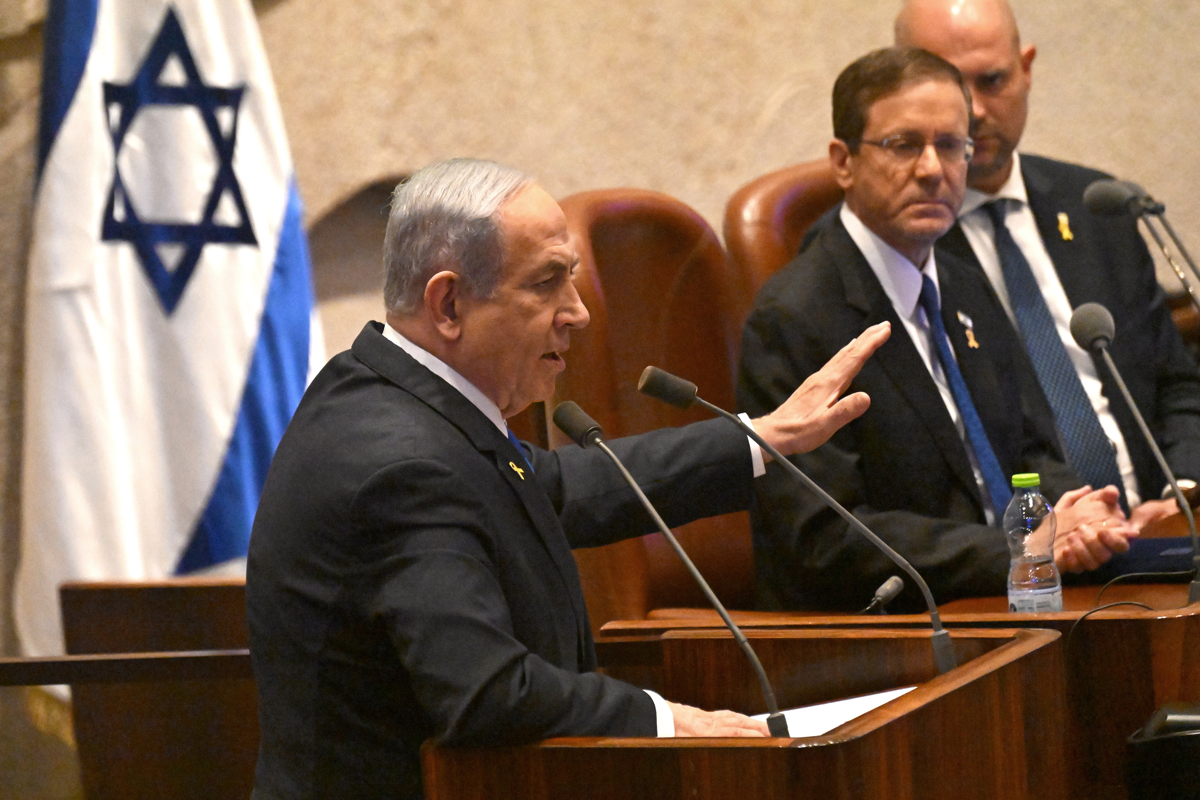 Jerusalem (-), 28/10/2024.- Israeli Prime Minister Benjamin Netanyahu (L) speaks at the opening of the 25th Knesset session as Israeli President Isaac Herzog (C) listens in Jerusalem, 28 October 2024. Israel opened its Knesset session marking the anniversary of the 'Swords of Iron' war, Israel's ground operations in the Gaza Strip. More than 43,000 Palestinians and over 1,400 Israelis have been killed, according to the Palestinian Health Ministry and the Israel Defense Forces (IDF), since Hamas militants launched an attack against Israel from the Gaza Strip on 07 October 2023, and the Israeli operations in Gaza and the West Bank which followed it. (Jerusalén) EFE/EPA/DEBBIE HILL / POOL