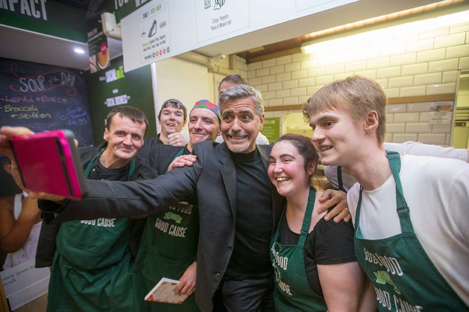 George Clooney conversó con empleados que con anterioridad fueron indigentes y ahora trabajan en la cadena de establecimientos que dona todos sus beneficios a obras de caridad.  / Efe