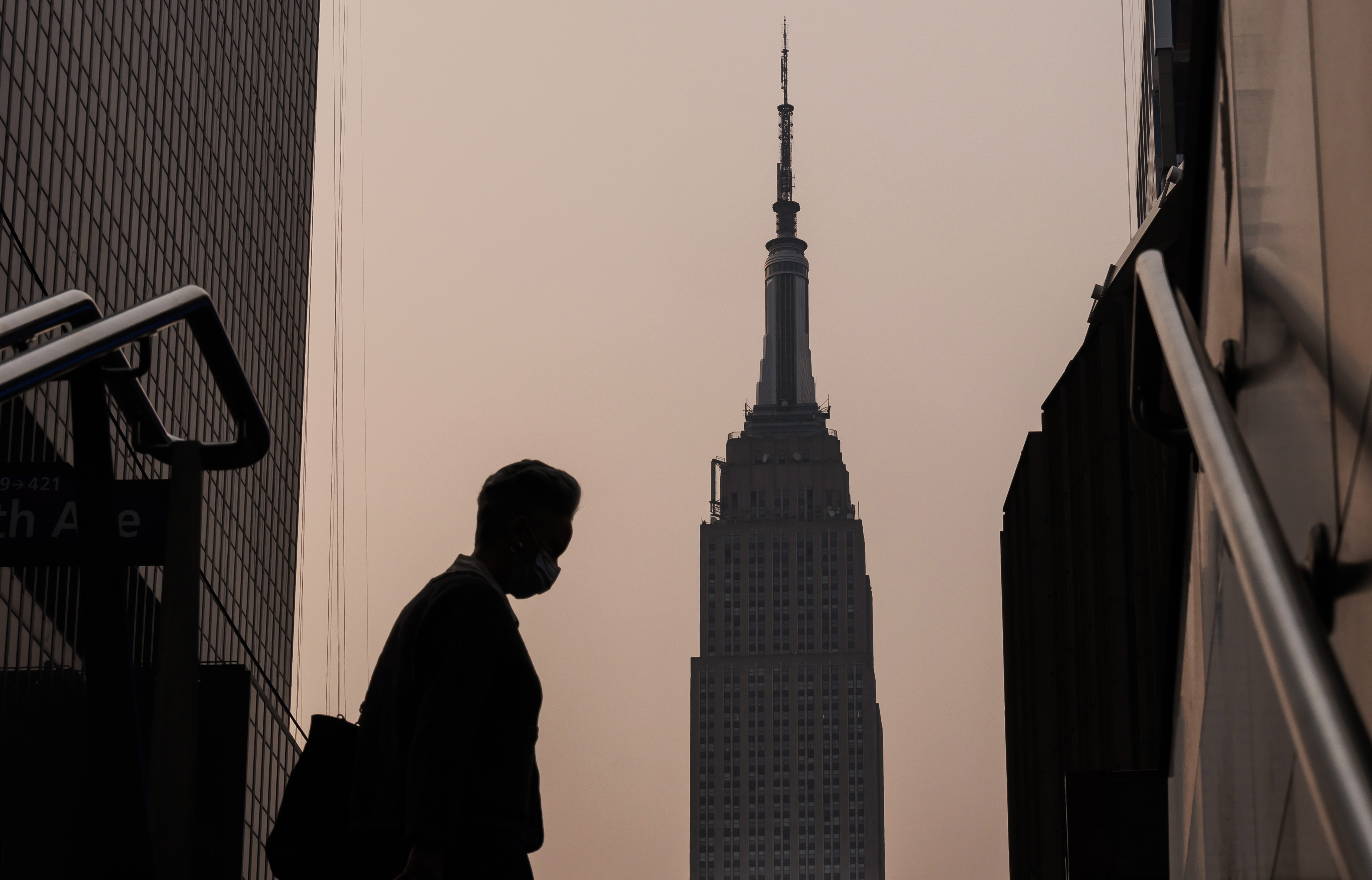 New York (United States), 07/06/2023.- The Empire State Building stands in the background as a person wearing a mask walks on a hazy morning due to smoke from wildfires burning in Canada, in New York, USA, 07 June 2023. An air quality alert was issued for the whole of New York City as a result of the smoke, which affects large portions of the northeastern United States. (Incendio, Estados Unidos, Nueva York) EFE/EPA/JUSTIN LANE