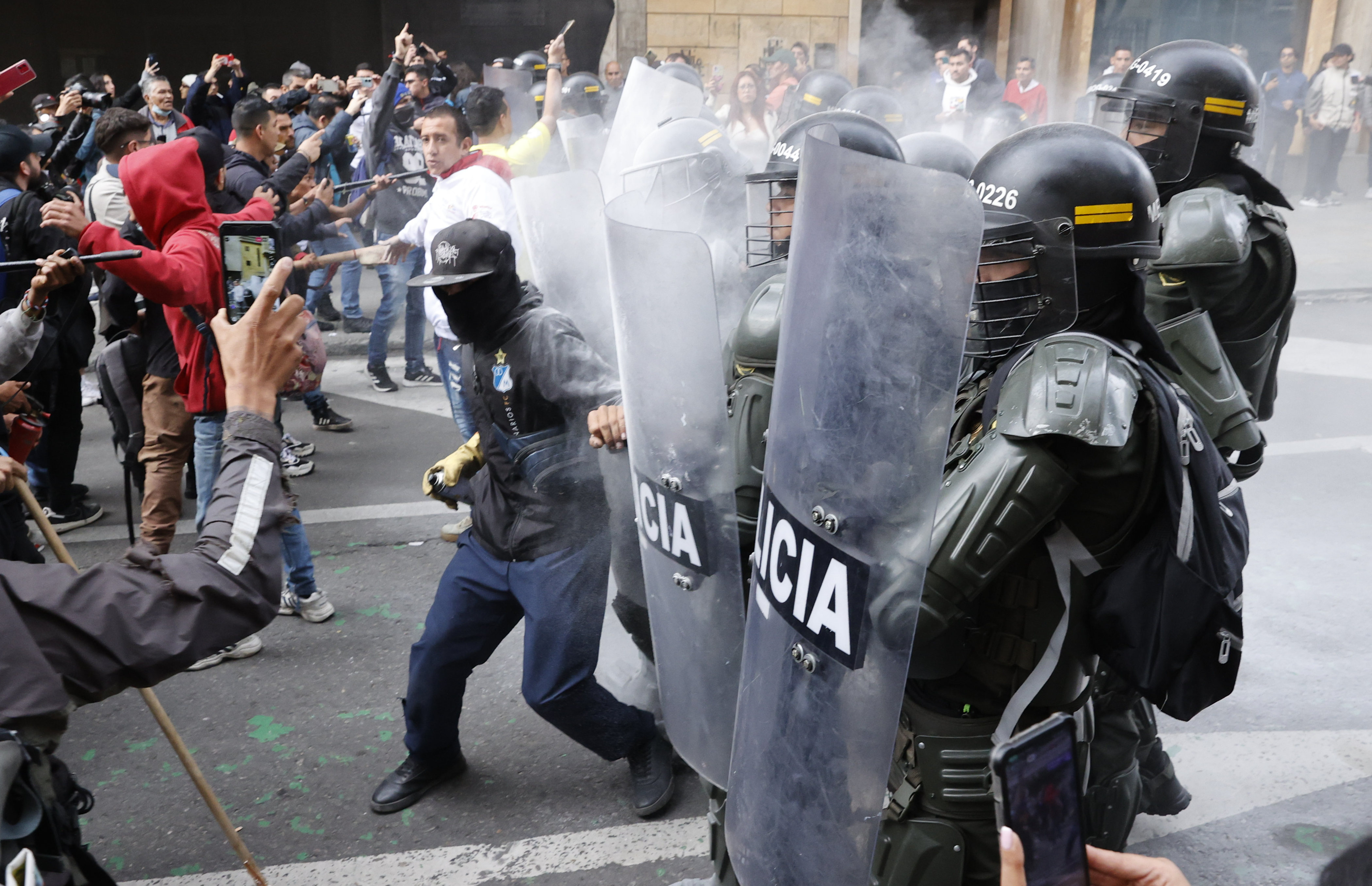 AME7197. BOGOTÁ (COLOMBIA), 08/02/2024.- Personas se enfrentan con la Policía durante una protesta hoy en Bogotá (Colombia). El presidente de la Corte Suprema de Justicia de Colombia, Gerson Chaverra, condenó este jueves en duros términos el "bloqueo violento e ilegal" de manifestantes afines al Gobierno al Palacio de Justicia, situado en el centro de Bogotá, acto que consideró "inaceptable". EFE/Mauricio Dueñas Castañeda