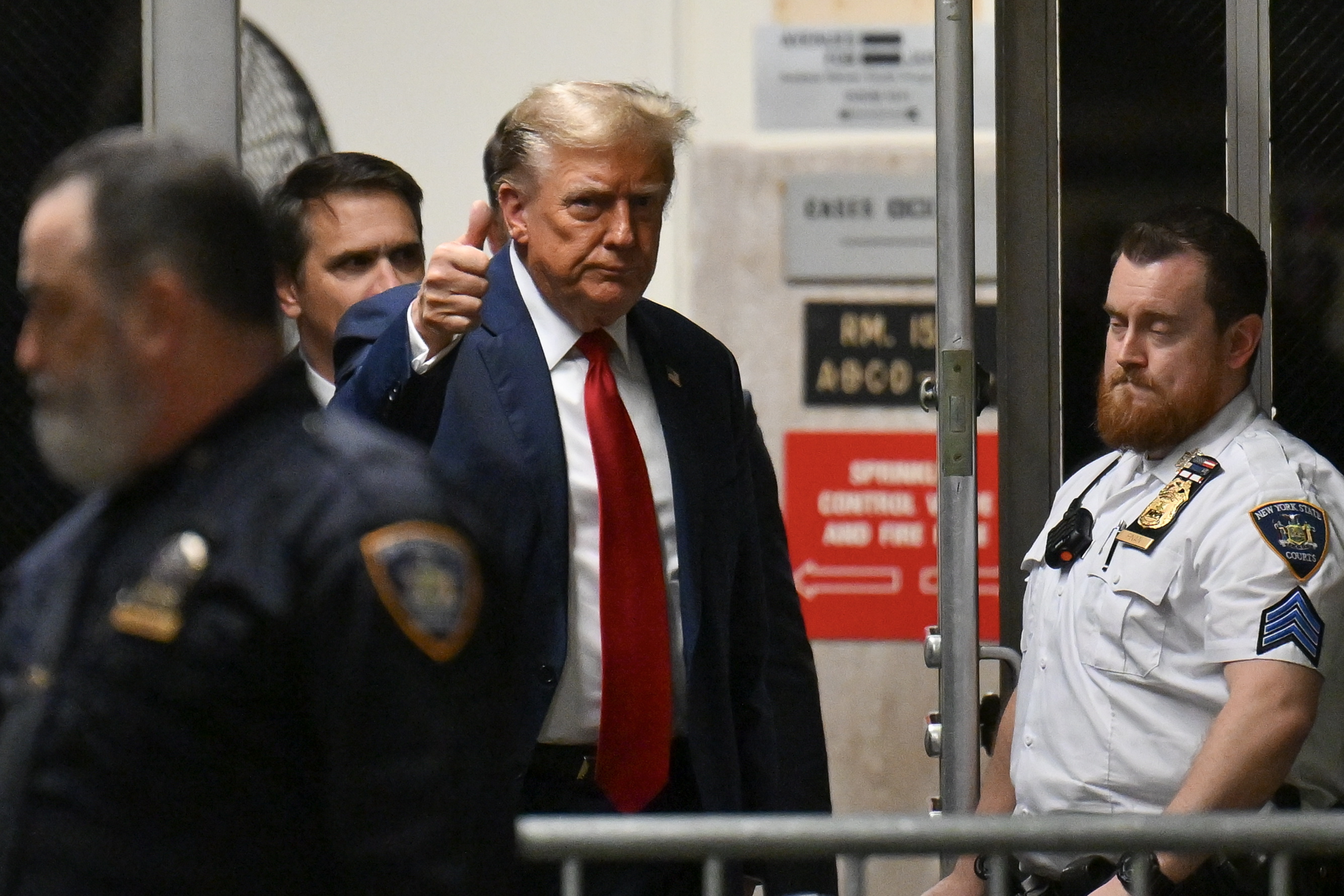 New York (United States), 15/04/2024.- Former US President Donald Trump (C) gives a thumbs up as he walks to the courtroom after a break during the first day of his trial for allegedly covering up hush money payments linked to extramarital affairs, at Manhattan Criminal Court in New York City, New York, USA, 15 April 2024. Trump is charged with 34 felony counts of falsifying business records related to payments made to adult film actress Stormy Daniels during his 2016 presidential campaign. (tormenta, Nueva York) EFE/EPA/ANGELA WEISS / POOL