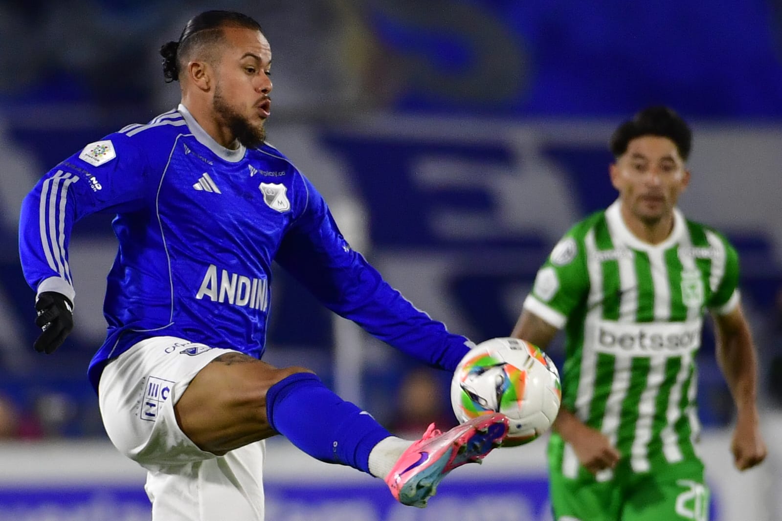 Leonardo Castro, delantero de Millonarios, controla el balón con el argentino Milton Casco, lateral izquierdo de Atlético Nacional, de fondo.