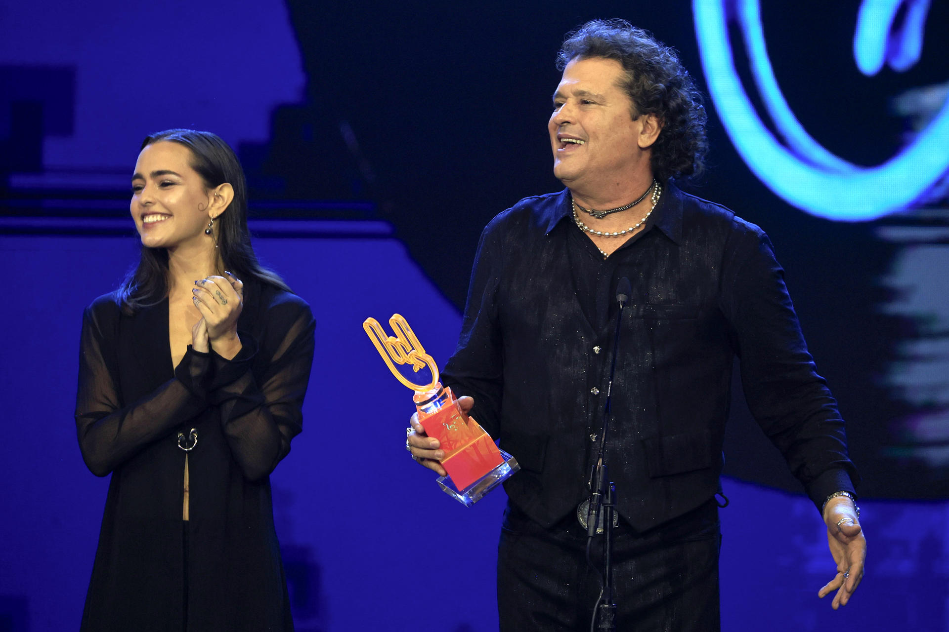 AME8731. SAN JUAN (PUERTO RICO), 04/06/2026.- El cantante Carlos Vives (d) recibe junto a su hija Lucy Vives el premio ícono global masculino en los Premios Tu Música Urbano 2026 este jueves, en el Coca-Cola Music Hall en San Juan (Puerto Rico). EFE/ Thais Llorca
