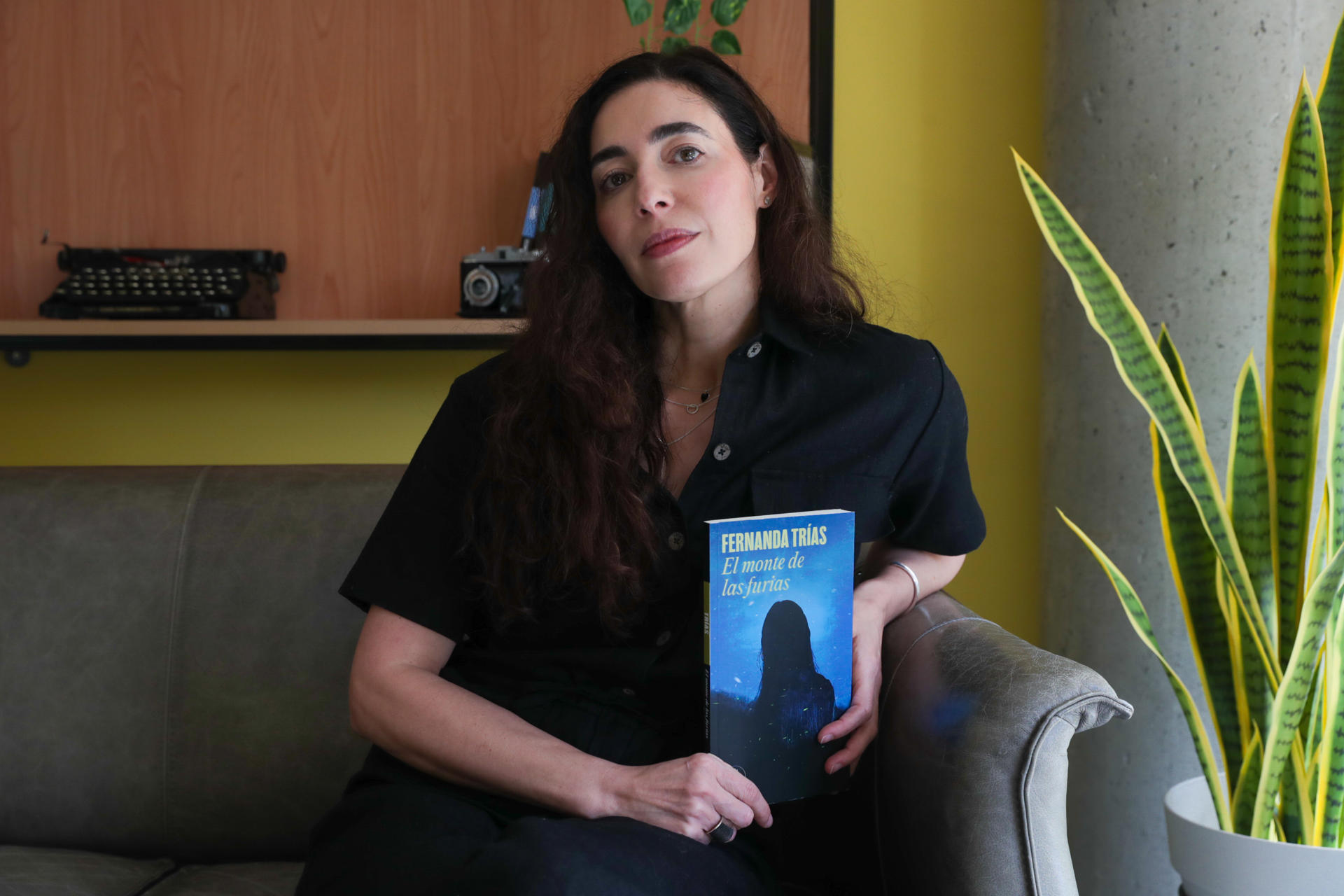 AME8247. MONTEVIDEO (URUGUAY), 11/04/2025.- Fotografía del 3 de abril de 2025 de la escritora uruguaya Fernanda Trías posando con su ejemplar de la novela 'El monte de las furias' durante una entrevista con EFE en las oficinas de Penguin Random House, en Montevideo (Uruguay). Consciente de que el arte "siempre se adelanta" y plantea "nuevas maneras de estar en el mundo", Fernanda Trías invita en su nueva novela a vislumbrar un "horizonte utópico" donde humanidad y naturaleza se cuidan y coexisten en armonía. EFE/ Alejandro Prieto
