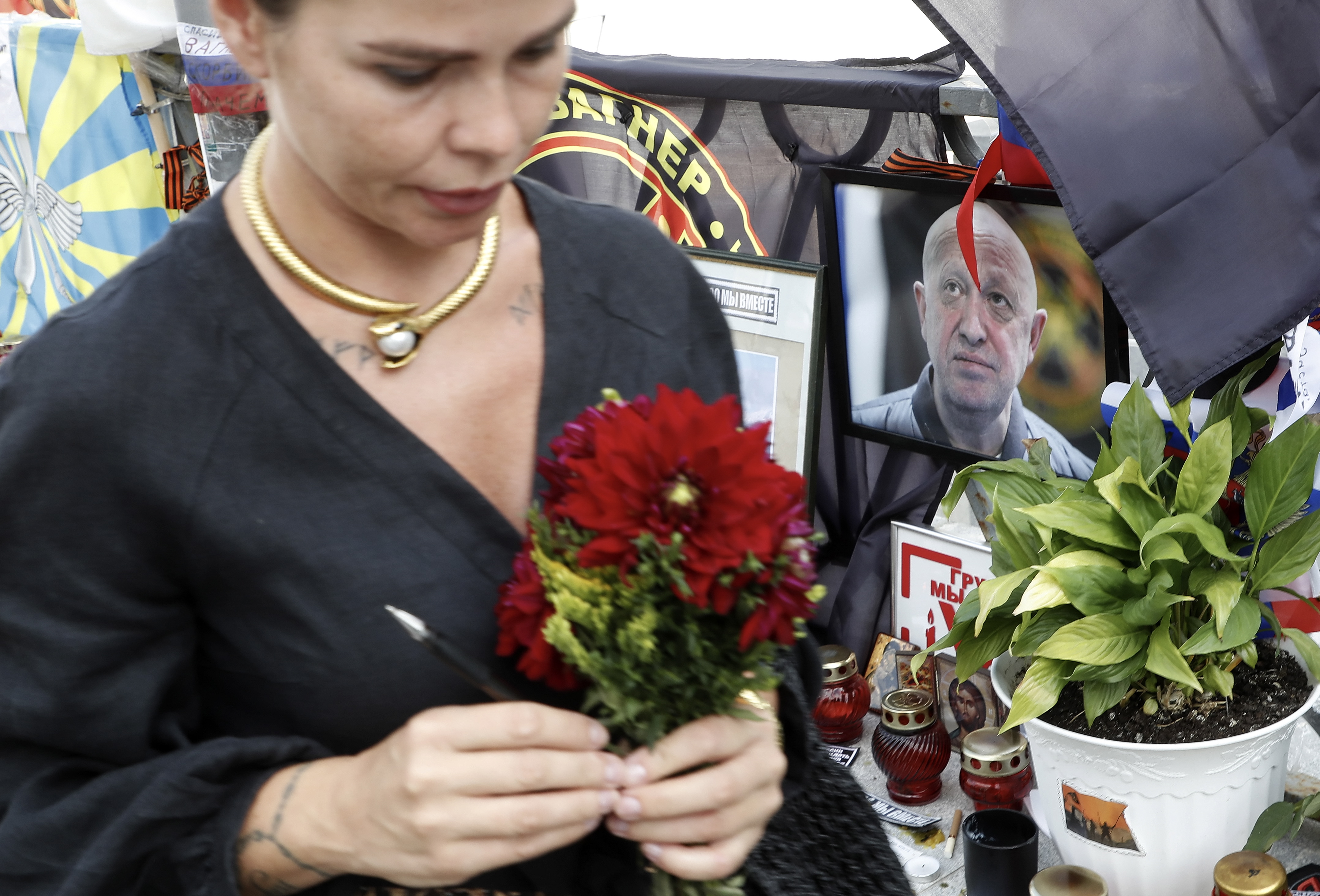 Moscow (Russian Federation), 28/08/2023.- A woman holds flowers as she stands in front of a portrait of Wagner Group chief Yevgeny Prigozhin at an informal memorial in his tribute in Moscow, Russia, 28 August 2023. An investigation was launched into the crash of an aircraft in the Tver region in Russia on 23 August 2023, the Russian Federal Air Transport Agency said in a statement. Among the passengers was Wagner chief Yevgeny Prigozhin, the agency reported. According to the results of genetic testing on the 10 bodies recovered at the crash site, Russian authorities on August 27 confirmed the death of Yevgeny Prigozhin. (Rusia, Ucrania, Moscú) EFE/EPA/MAXIM SHIPENKOV