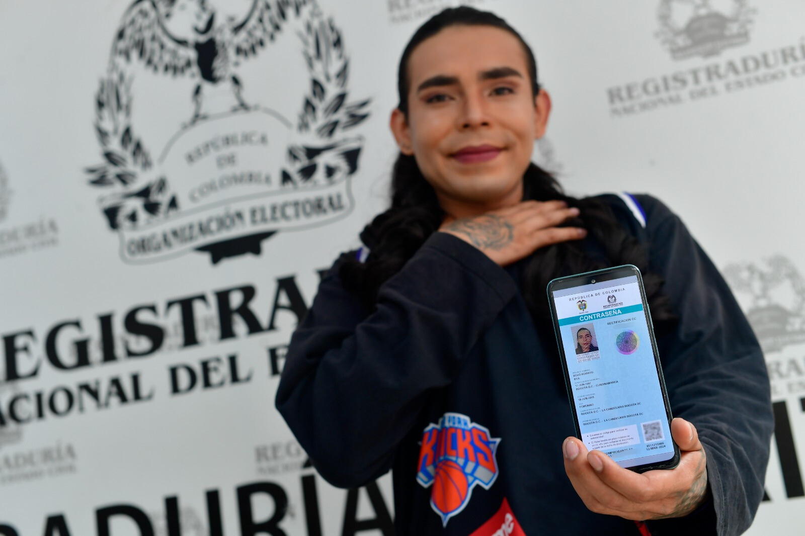 Naia, una mujer trans, posa con su nueva cédula digital.