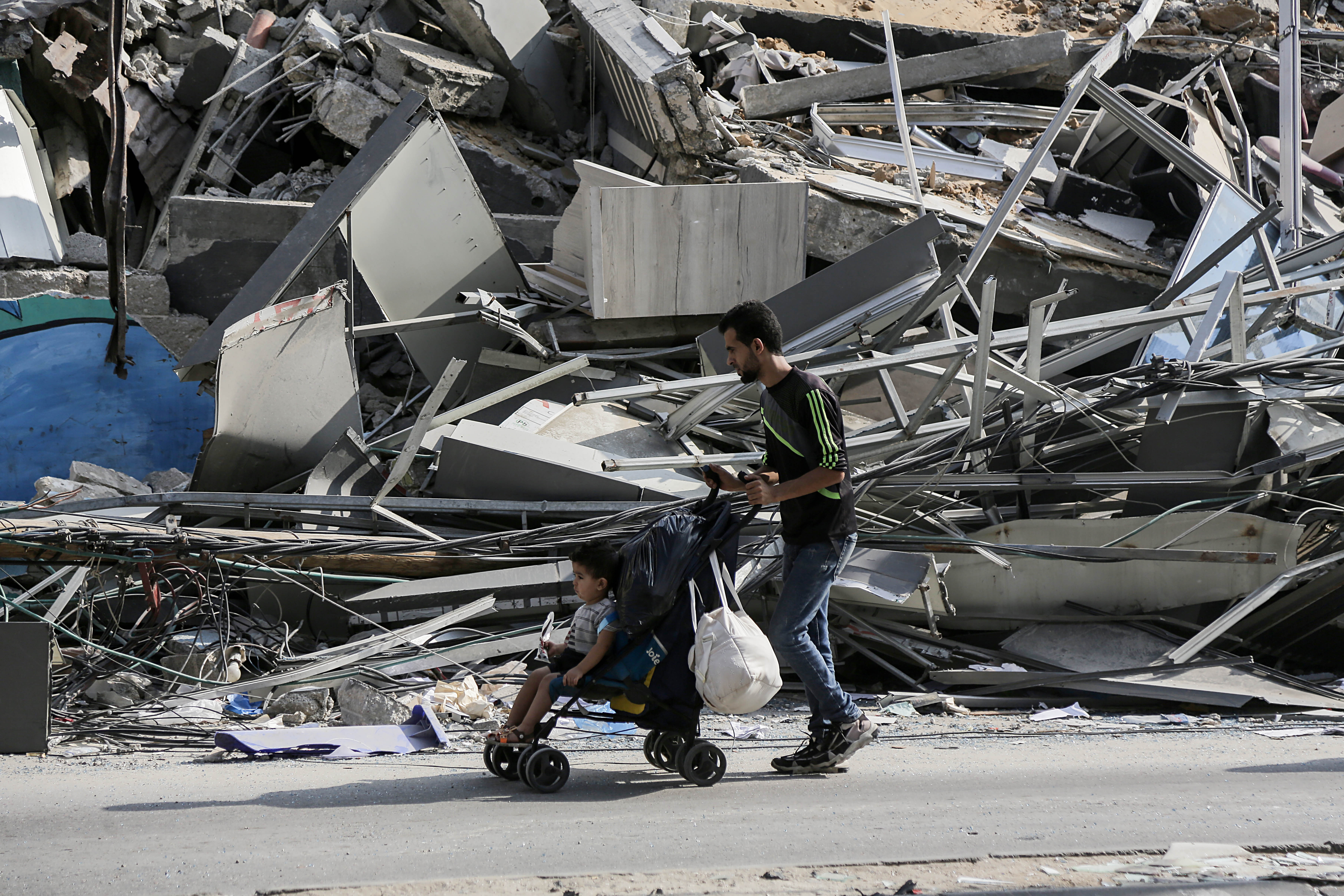 Gaza City (---), 14/10/2023.- A man pushes a stroller past debris as residents of Gaza City begin to evacuate following an Israeli warning of increased military operations in the Gaza strip, 14 October 2023. The Israeli Defense Force (IDF) on 13 October had called for the evacuation of all civilians of northern Gaza ahead of an expected ground invasion. EFE/EPA/HAITHAM IMAD