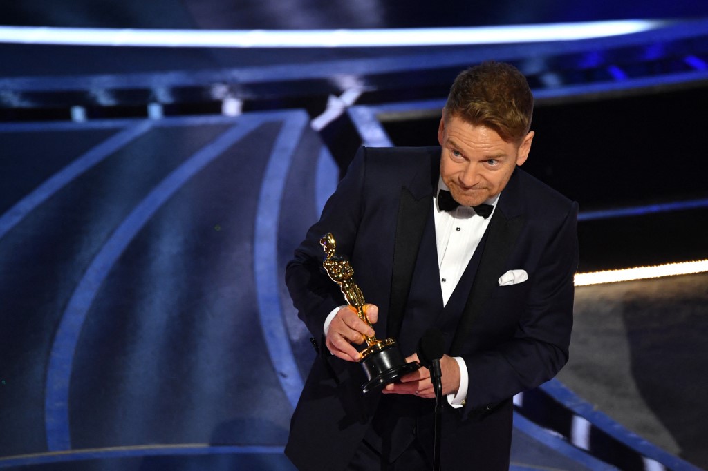El cineasta británico Kenneth Branagh acepta el premio al Mejor Guión Original por "Belfast" en el escenario durante la 94ª edición de los Óscar.