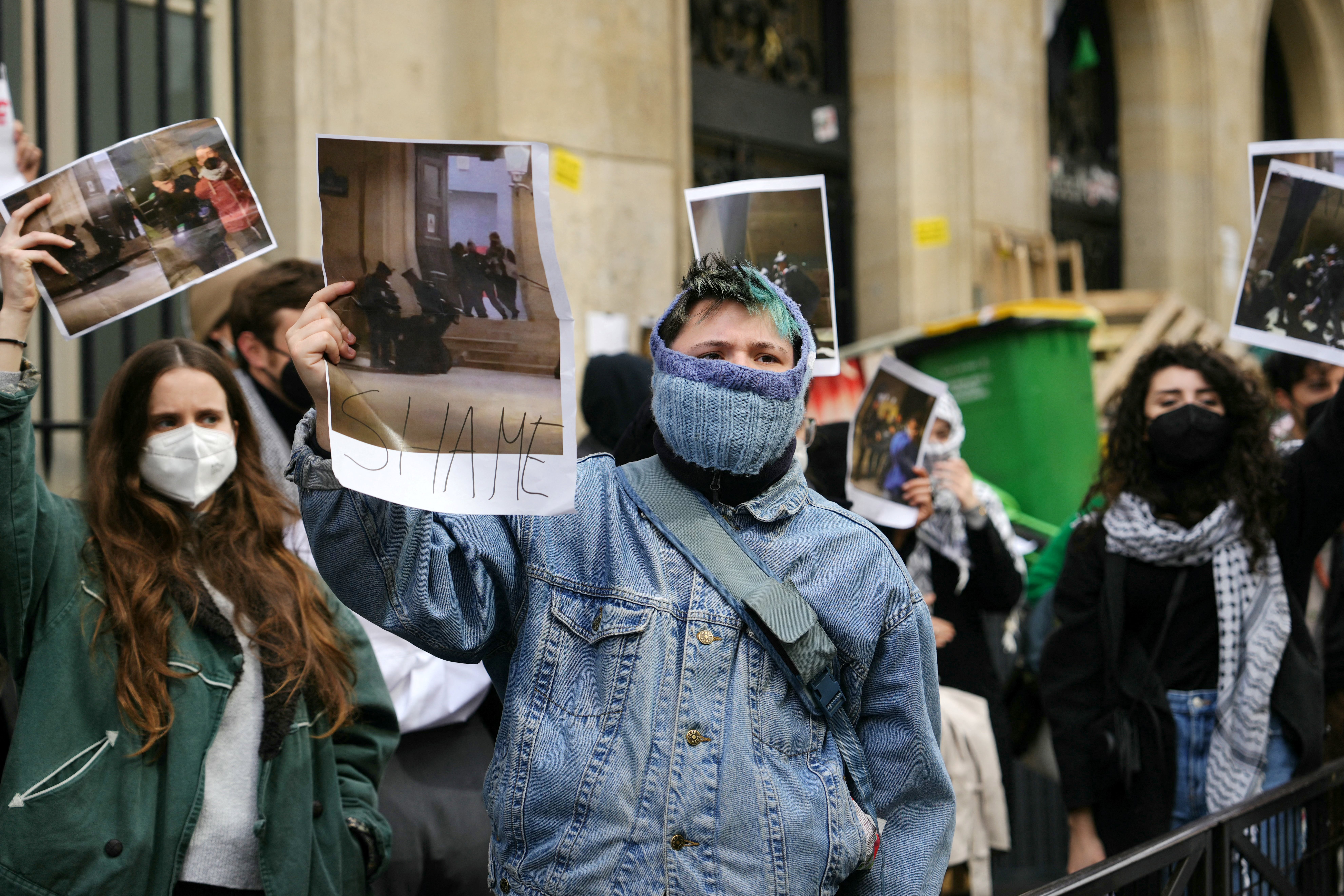 Protesters raise pictures as students occupy a building of the Institute of Political Studies (Sciences Po Paris) by students in support of Palestinians, in Paris on April 26, 2024.