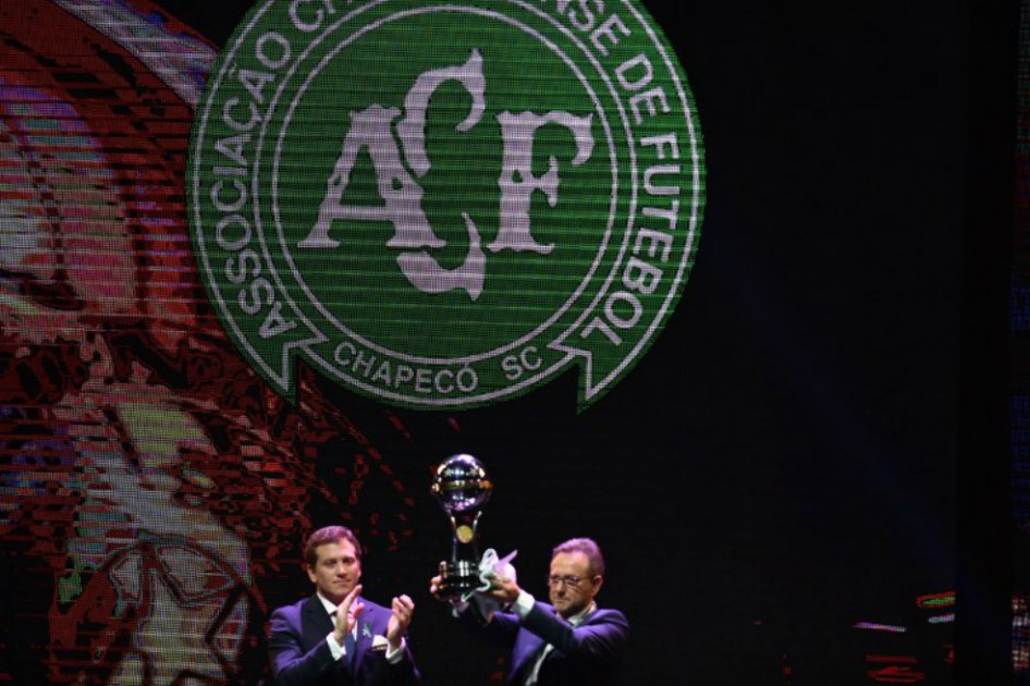 El presidente de Conmebol, Alejandro Domínguez, le entrega a Plinio David, presidente de Chapecoense, el trofeo de la Copa Sudamericana. / AFP