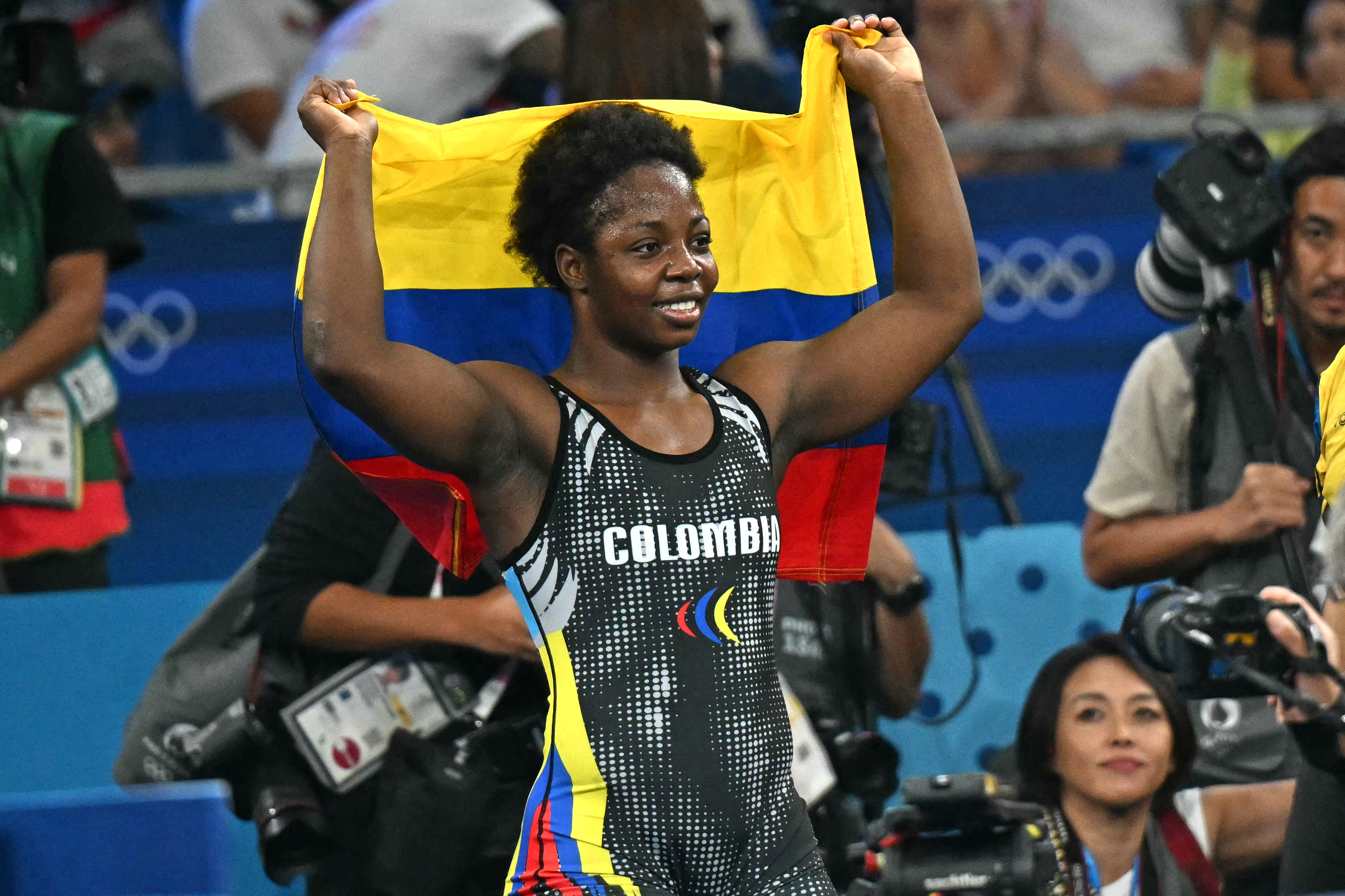 Colombia's Tatiana Renteria Renteria celebrates with her national flag after beating Ecuador's Genesis Rosangela Reasco Valdez in their women's freestyle 76kg wrestling bronze medal match at the Champ-de-Mars Arena during the Paris 2024 Olympic Games, in Paris on August 11, 2024. (Photo by Punit PARANJPE / AFP)