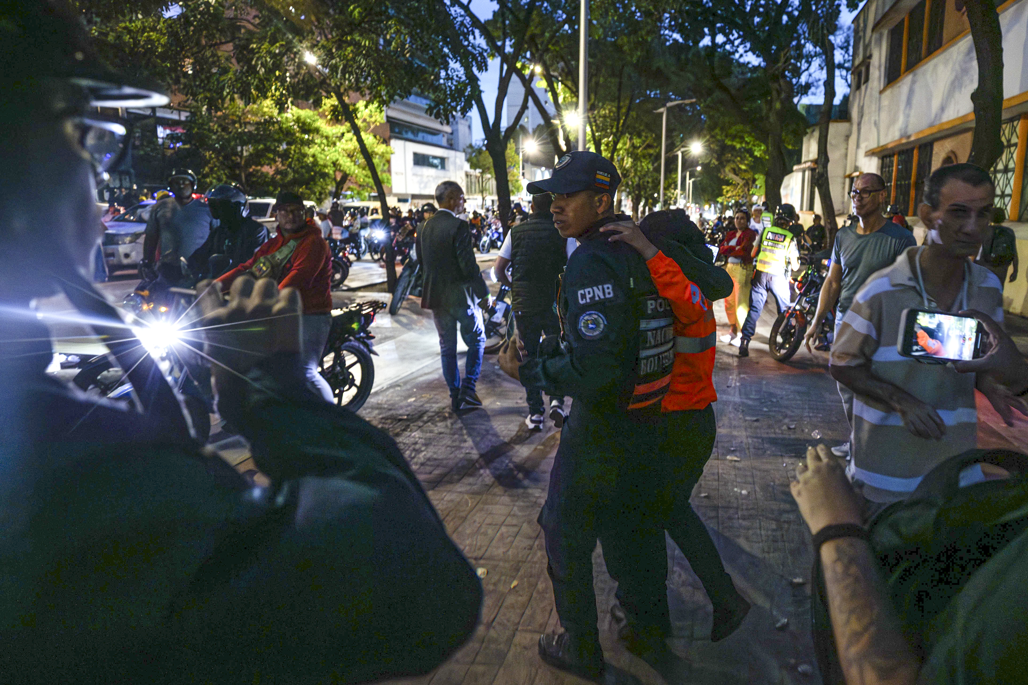AME6017. CARACAS (VENEZUELA), 28/07/2024.- Agentes intervienen en enfrentamientos entre seguidores del presidente de Venezuela y candidato a la reelección, Nicolás Maduro, con opositores este domingo, en Caracas (Venezuela). Varias decenas de motorizados que se identificaron como chavistas llegaron a un centro de votación en Caracas, donde se encontraban testigos opositores y ciudadanos que esperaban el comienzo del escrutinio de las elecciones presidenciales de este domingo, lo que dio lugar a una confrontación que acabó a golpes, ante la mirada impasible de los policías, que no intervinieron para detener la pelea. EFE/ Henry Chirinos