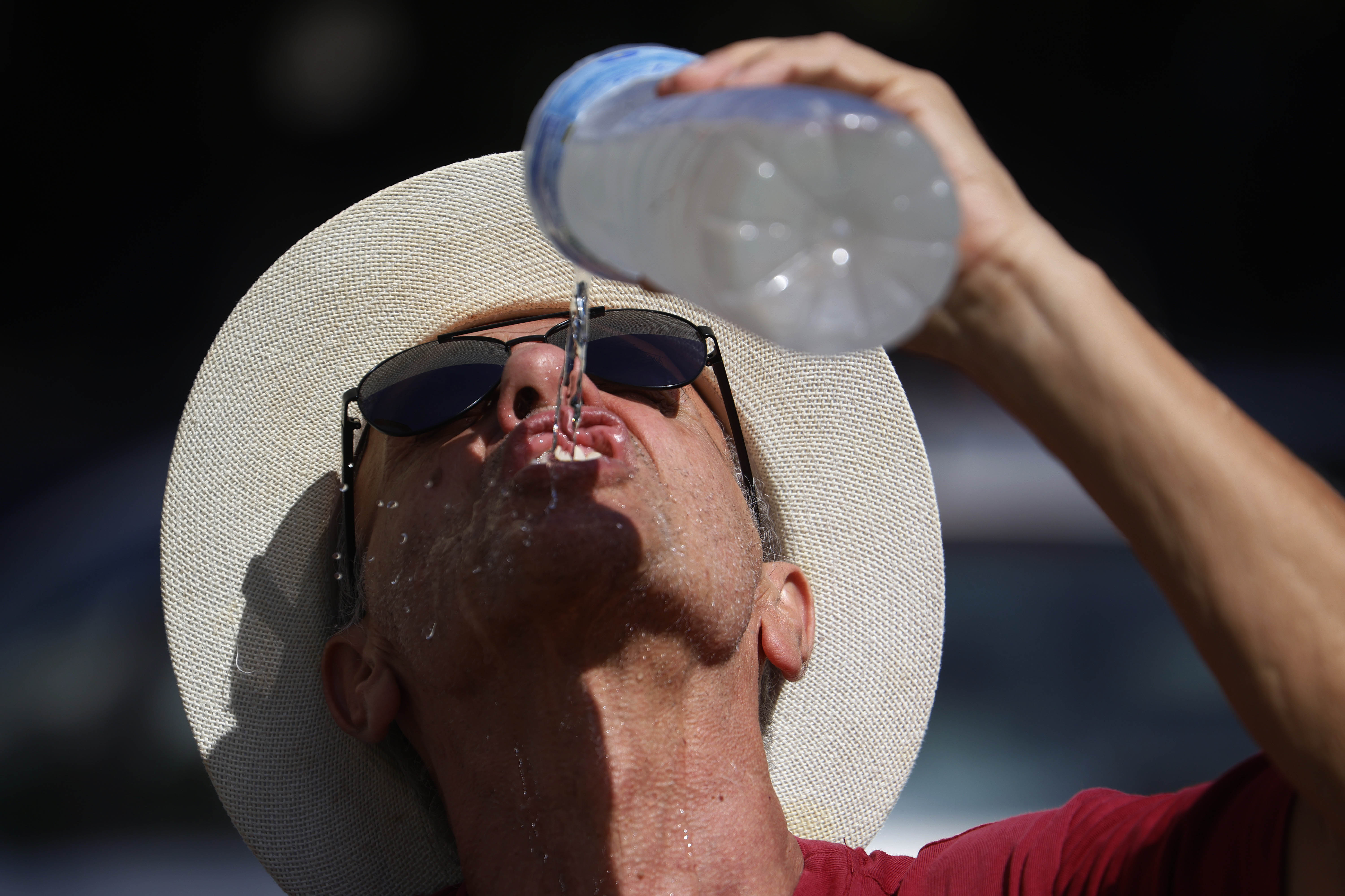 -FOTODELDÍA- CÓRDOBA, 09/08/2024.- Un hombre se refresca con agua de una botella mientras camina por el Puente Romano de Córdoba, este viernes en el que arranca una nueva ola de calor que podría ser la más intensa del verano hasta ahora, con máximas muy por encima de la media y temperaturas que tenderán a aumentar. EFE/Salas
