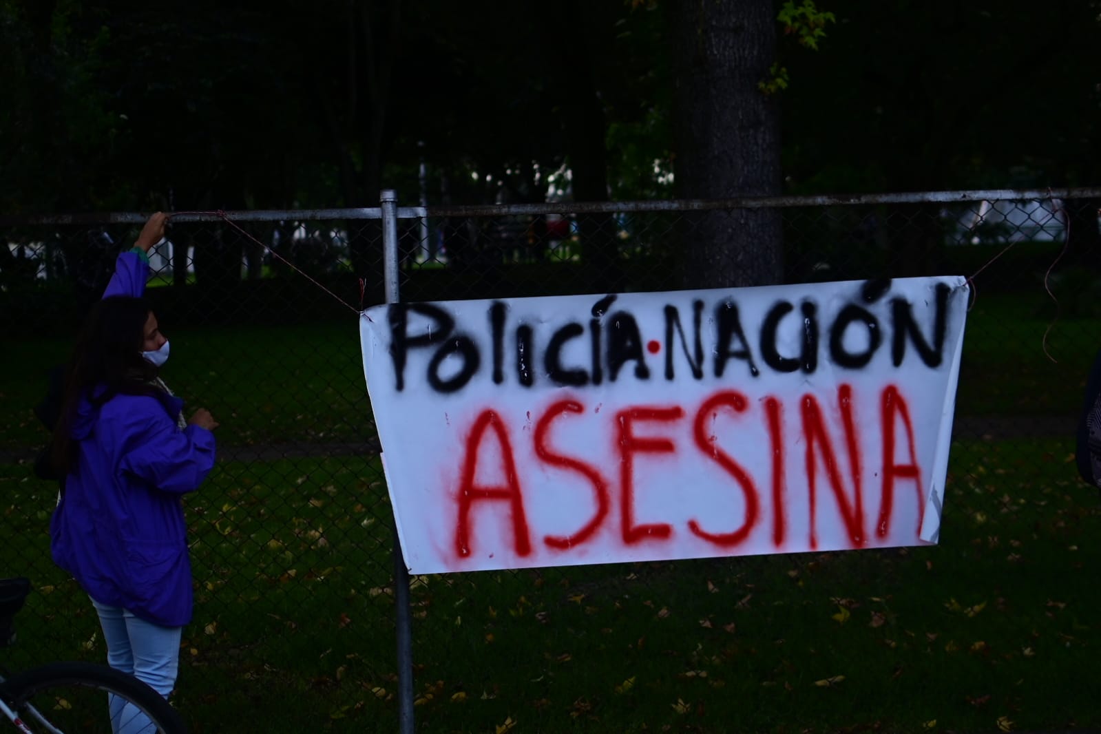 Una mujer mira uno de los carteles en el que se lee: Policía- Nación asesina