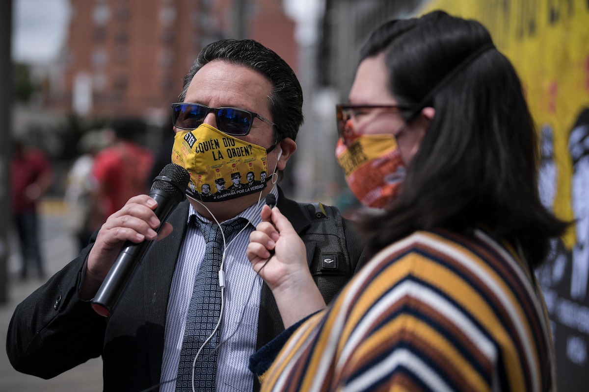 Dos personas están hablando con un micrófono en la mano.