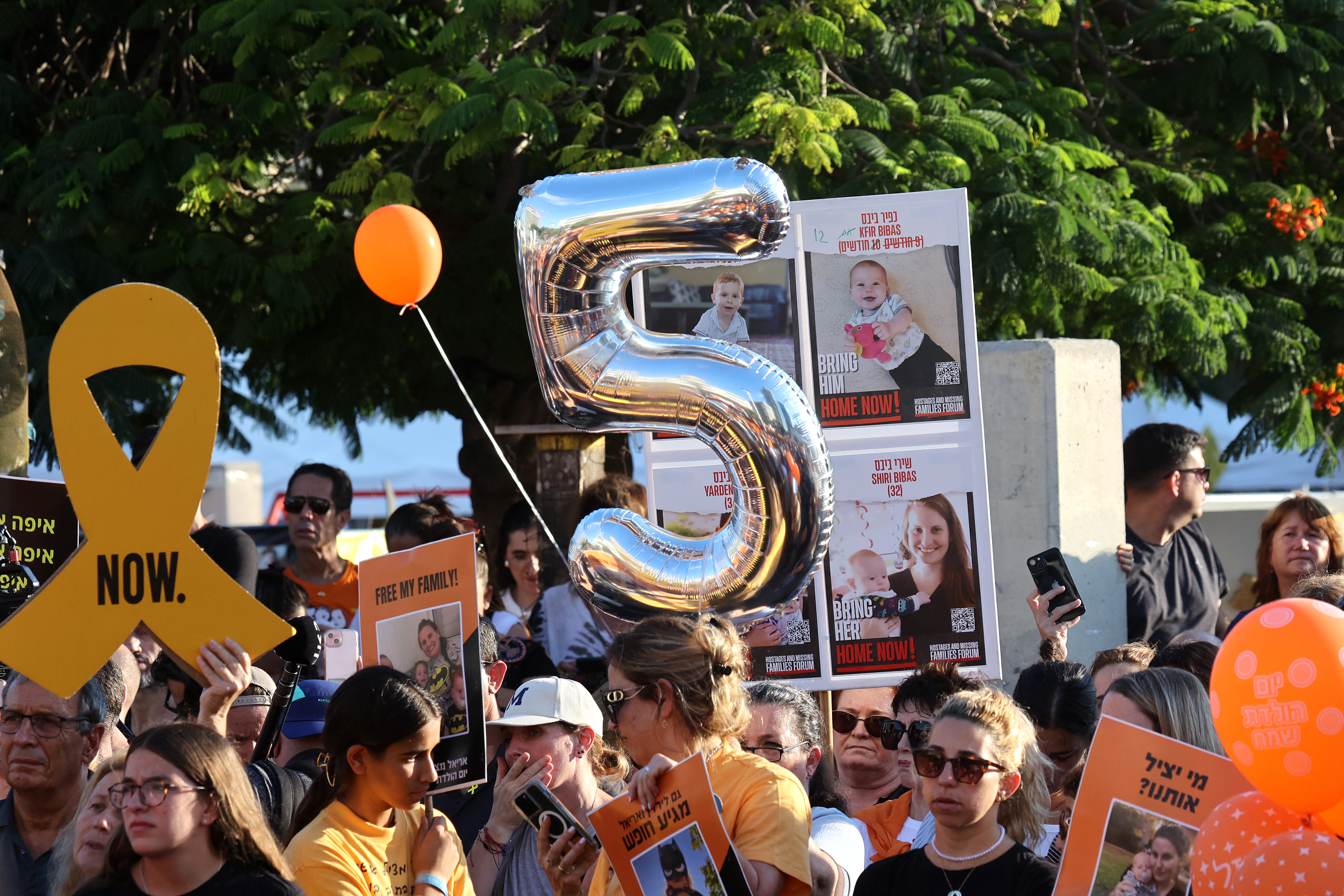 Participants lift placards and pictures during a gathering in Tel Aviv on August 5, 2024 to mark the fifth birthday of Ariel Bibas, held hostage in Gaza, and to call for the liberation of him and his family.