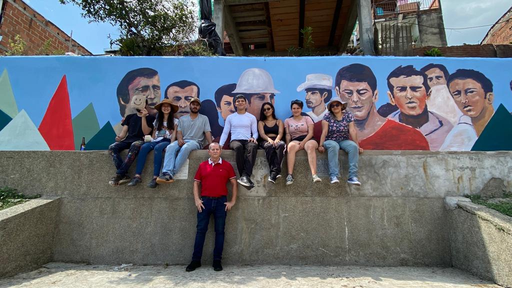 El presidente de Sutimac Santa Bárbara, Alveiro Mesa, con el "Sr. Ok" y el grupo de jóvenes de Santa Bárbara que realizaron el mural en el momento a los "Mártires del 23 de febrero de 1963".